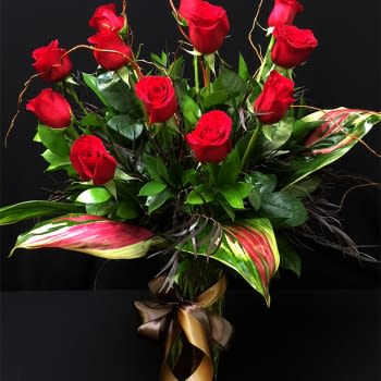 Deluxe Roses RHA12 - 1 dozen roses (as shown): $110 2 dozen roses: $195 3 dozen roses: $300 Roses don't have to look like they did in the 1950's. Times have changed and so have our designers take on this traditional arrangement. Utilizing darker fillers and greens - this arrangement is perfect for a an office or even for a &quot;man cave&quot; or female friend that likes traditional with a twist. While Red Roses are a perfect complement for this arrangement - feel free to specify a different choice color in special instructions. Orders for roses in colors other than Red, White &amp; Yellow should be placed 48 hours in advance to ensure availability.