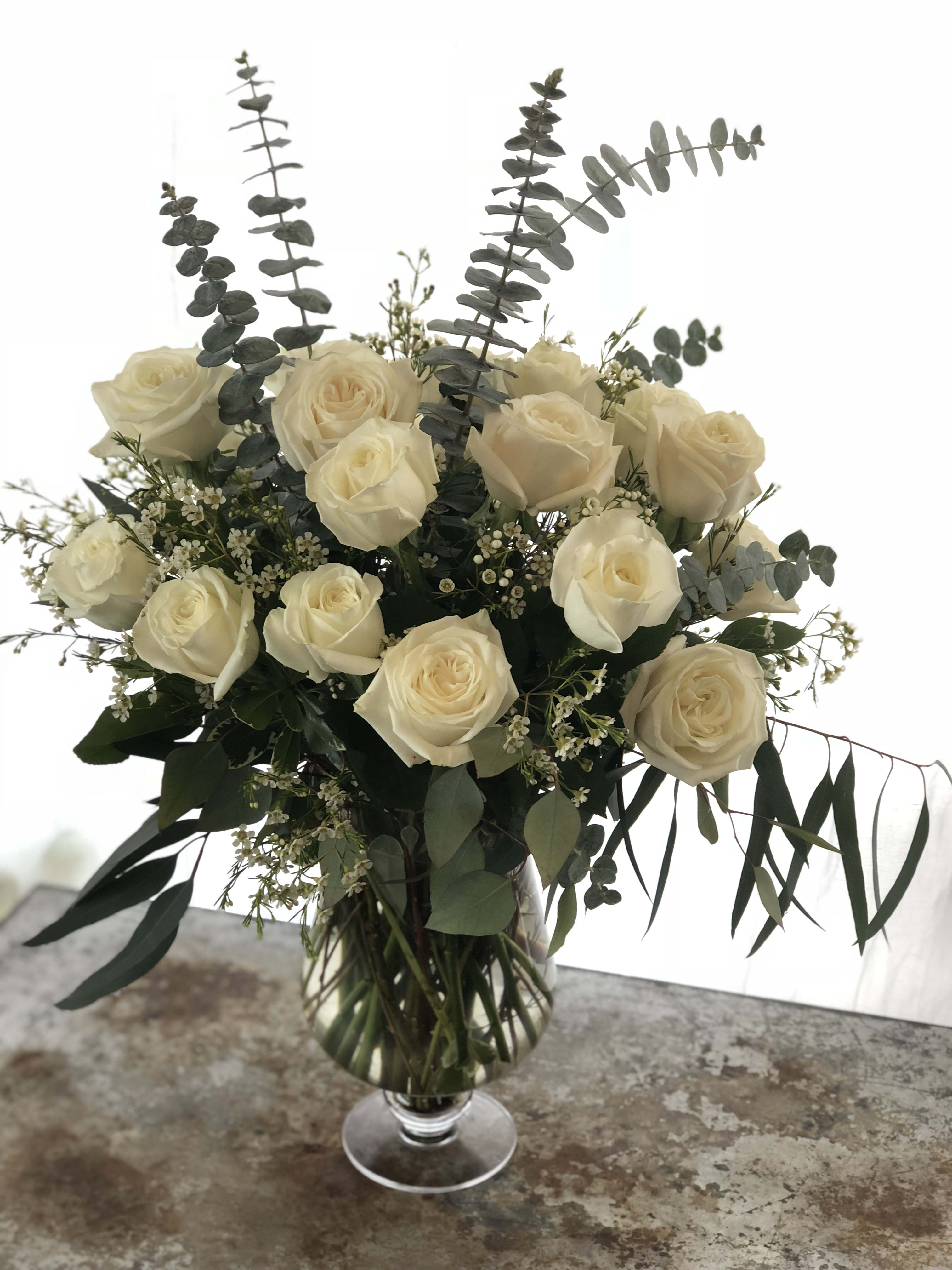 Eighteen Roses Eighteen Roses - A grand arrangement of eighteen premium roses arranged with subtle accents and assorted foliage. Unless specified in the column for additional comments this will be done with white roses.