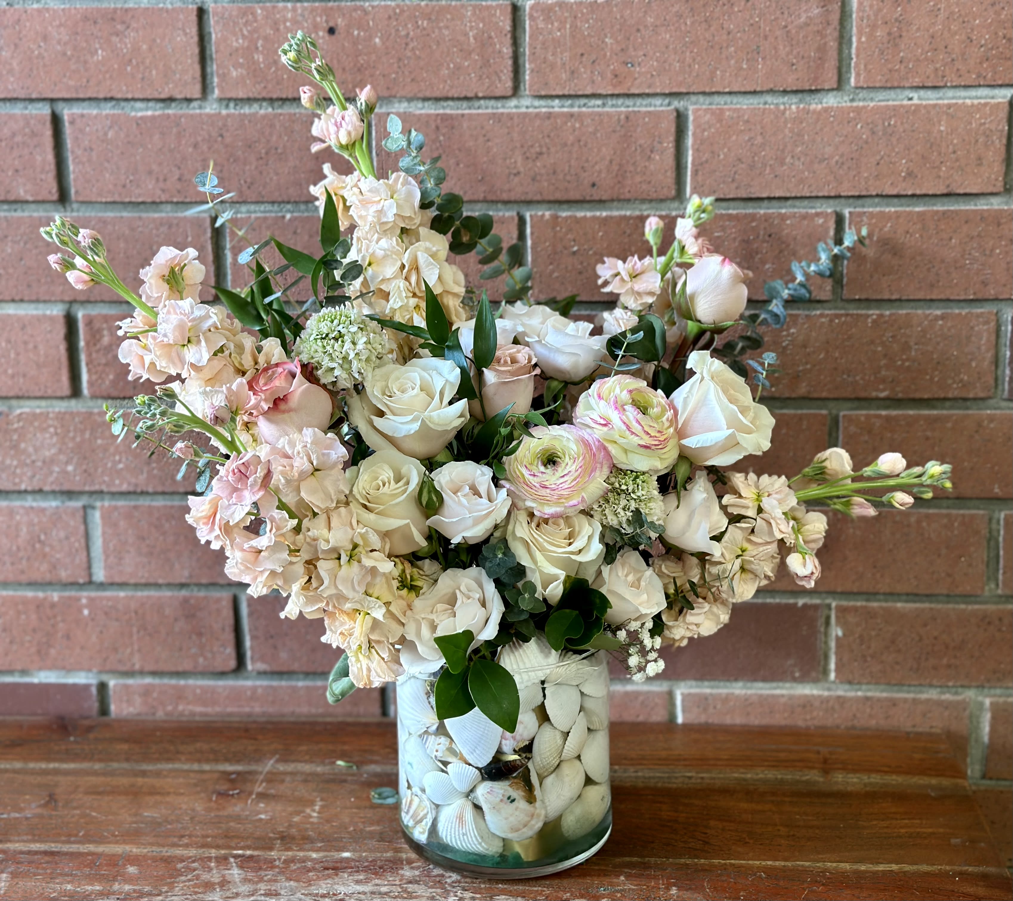 Bountiful Beach Bouquet Bountiful Beach Bouquet - Full vase of assorted sea shells Filled with fresh stock, ranunculus, roses, spray roses, scabiosa and touches of greenery