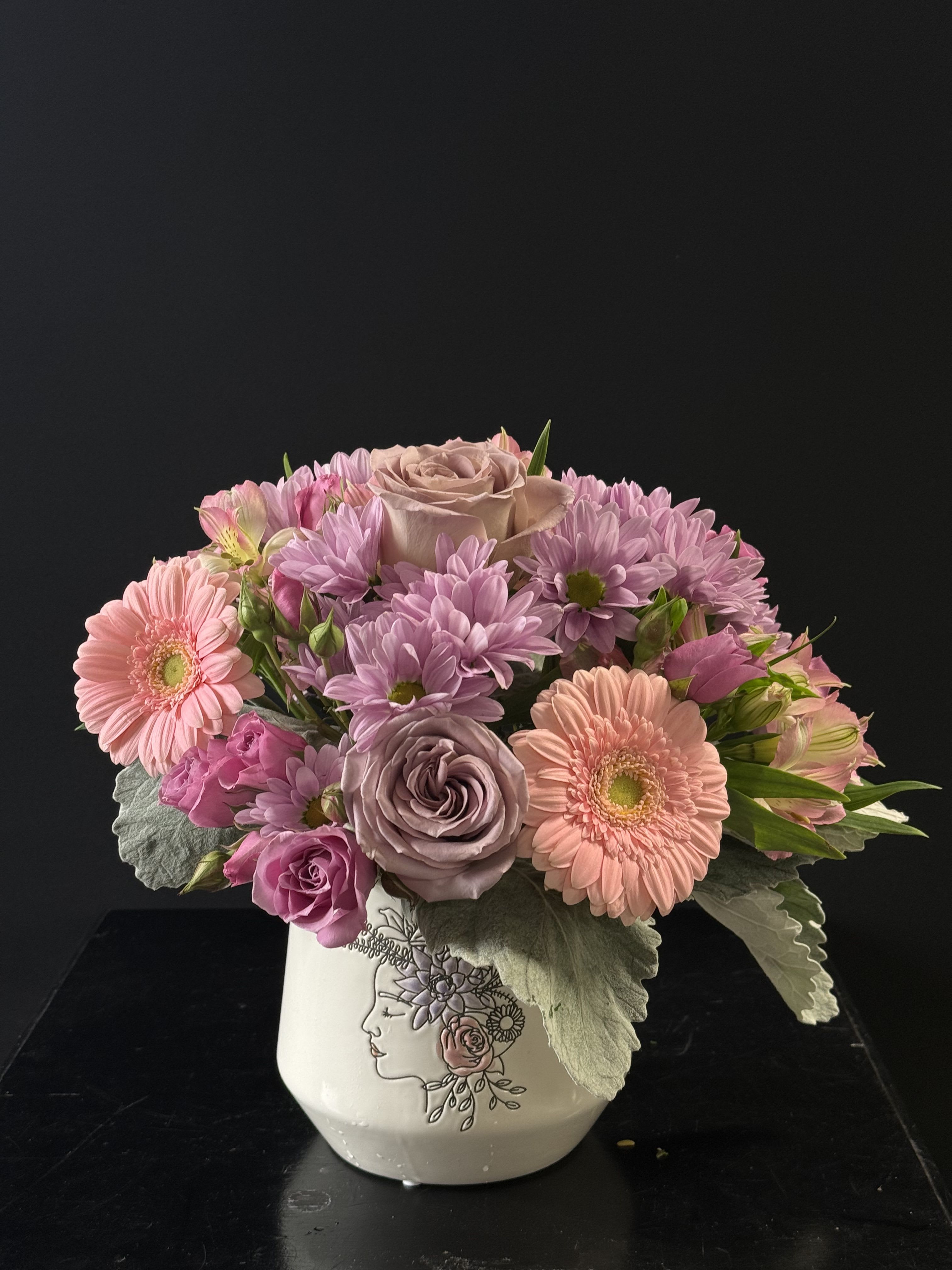 Flowers On My Mind - A rounded arrangement full of pinks and purples, roses, daisies, gerberas, spray roses, alstroemeria, and dusty miller.