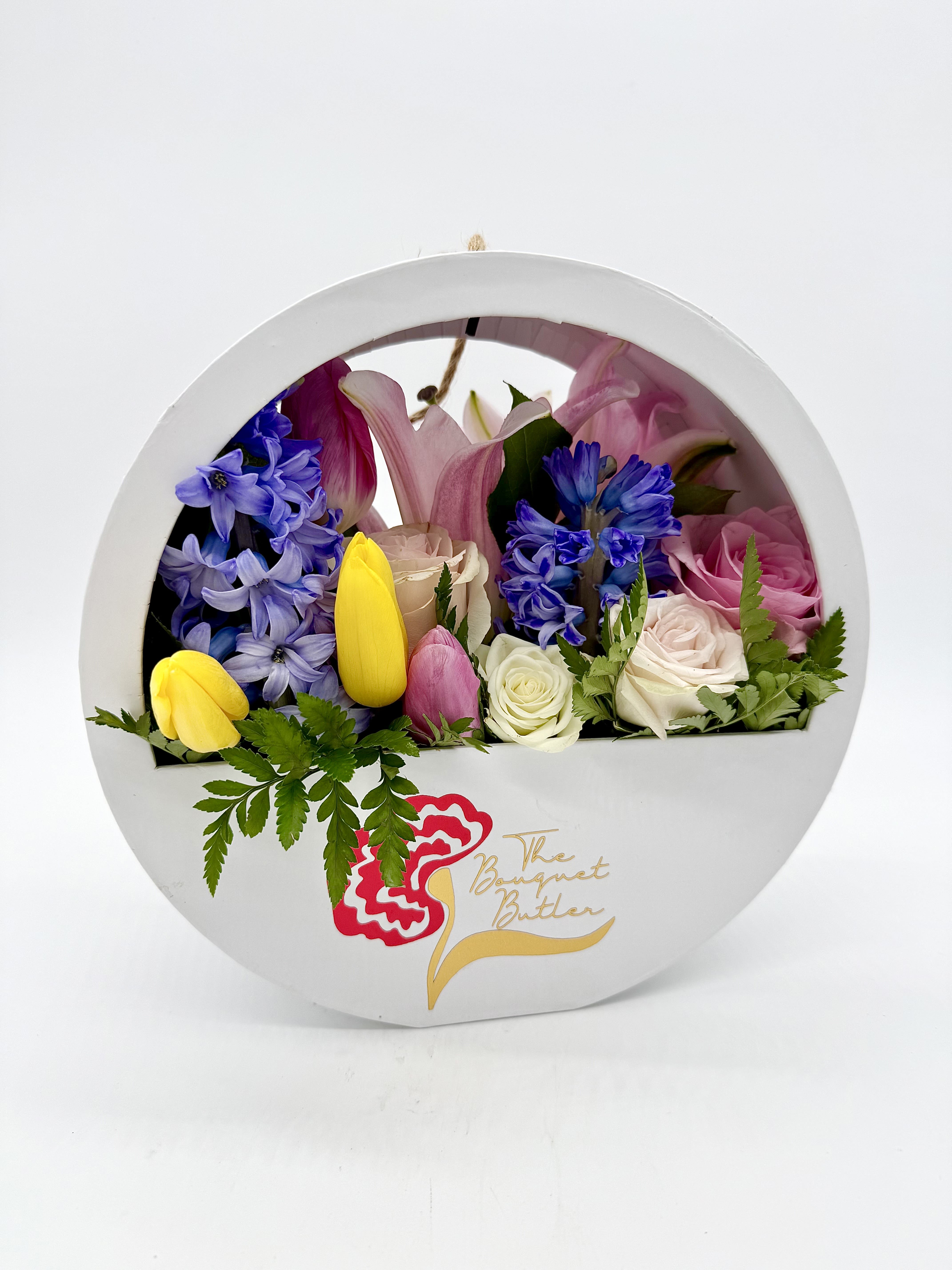 Mother’s Day Hanging Bloom Box - A soft, elegant mix of seasonal flowers and pastel roses, carefully arranged in our signature round white hanging box. Designed to be displayed with ease, this bloom box brings charm and color to any space—an elevated gift for the woman who does it all.