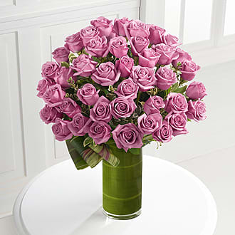 Sensational - Long Stem Lavender Roses in a Premium Glass Vase.  - They possess every beat of your heart. Offer them our finest premium lavender roses to create that unforgettable moment. Perfectly situated in a superior 10-inch clear glass cylindrical vase, this extravagant rose bouquet becomes a remarkable symbol of your endless love. Includes: 36 stems of 24-inch premium long-stemmed lavender roses, exotic foliage and a superior 10-inch clear glass cylindrical vase.
