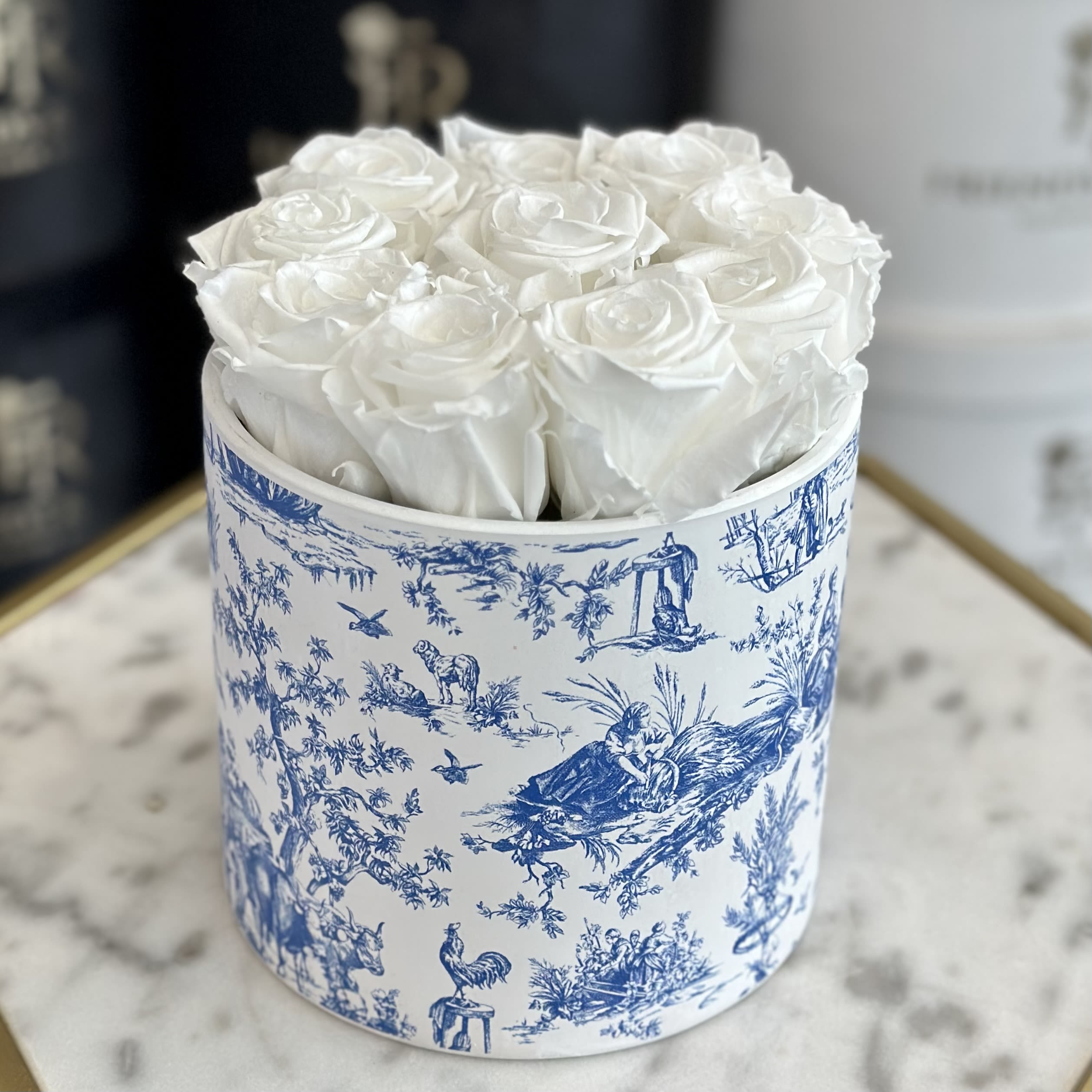 Lace of dew (Eternal Roses) - This elegant arrangement features 10 eternal roses in a white-and-blue vase, exuding timeless beauty. The soft blend of white and blue evokes freshness and serenity, while the vase complements the graceful, lasting blooms. Perfect for adding a touch of elegance to any space.