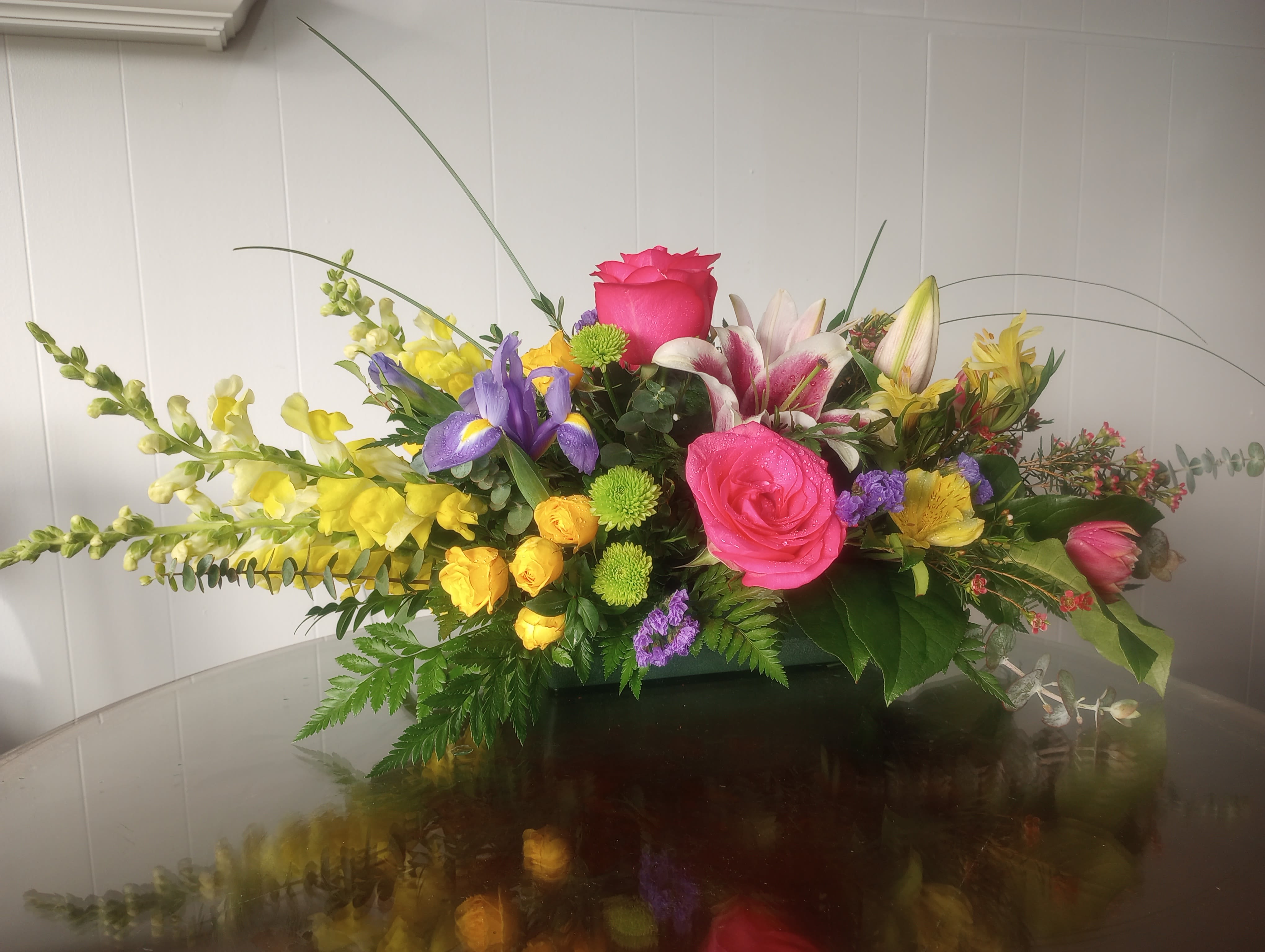 For my mom! For my mom! - Stargazers take center stage with hot pink roses. Yellow snapdragons and yellow spray roses with dark blue iris and pink tulips are supporting actors. For background and atmosphere we have green anthos, pink wax flower with fresh greens in a low container.