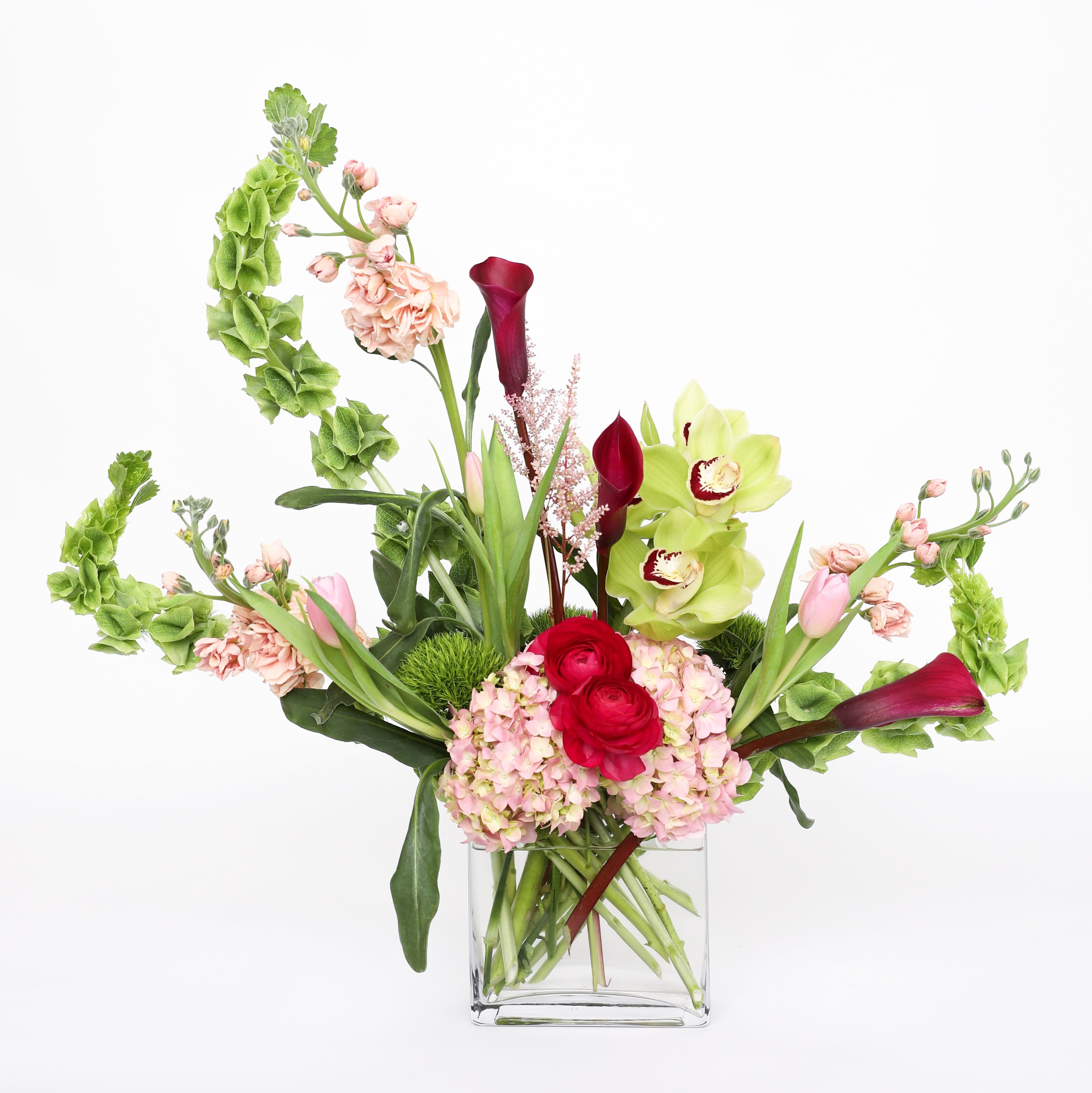 Amor Mio Amor Mio - This love of mine is standing in it's beauty. With bells of Ireland, stock, mini calla lilies, hydrangea, ranunculus, cymbidium, tulips, astilbe and dianthus.