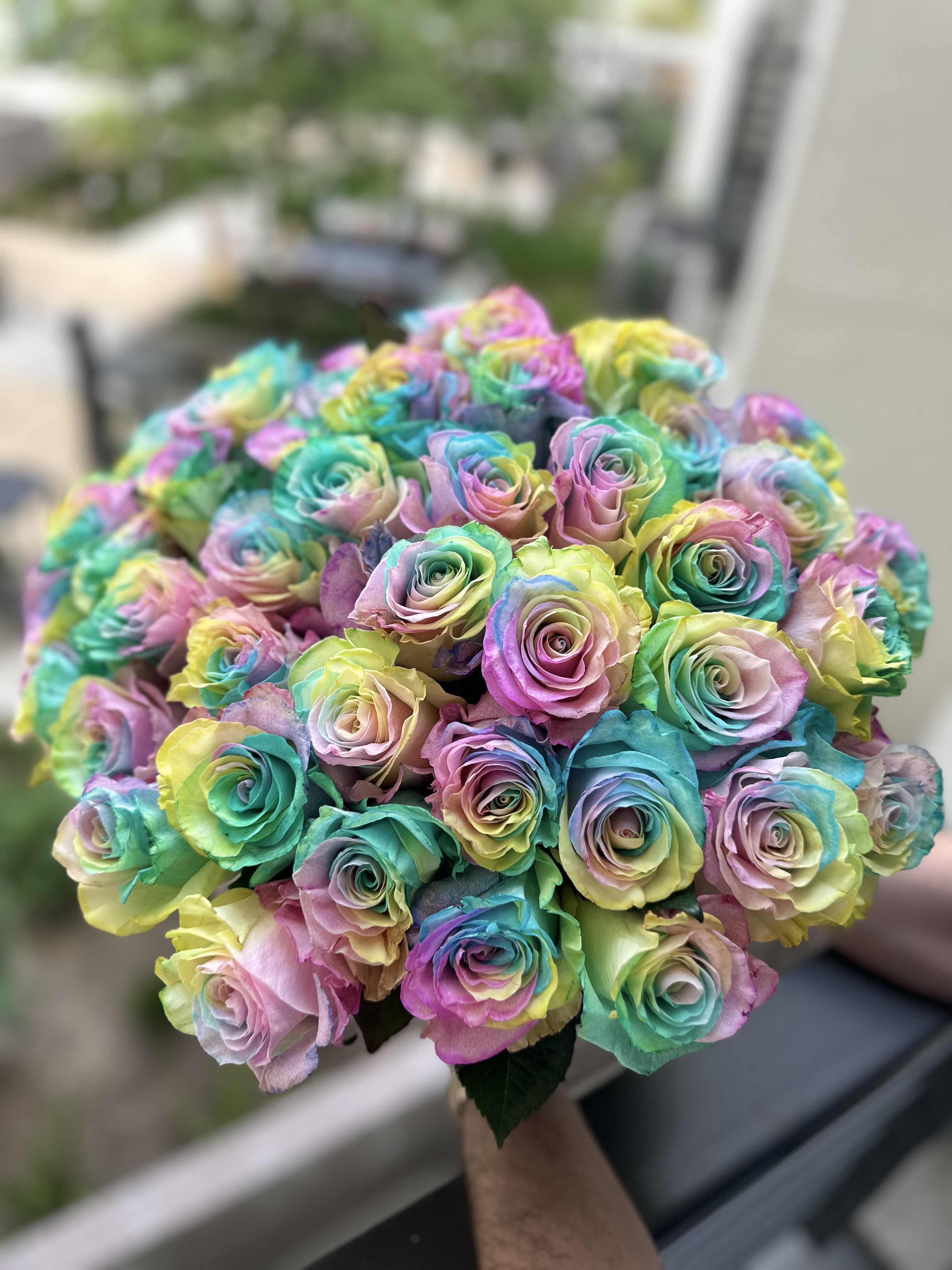 Rainbow mood - This bouquet is a true celebration of color and joy! Vibrant rainbow roses look as if they were gathered from drops of happiness, creating a magical and uplifting effect.  Tied with a ribbon, it looks both stylish and festive — like a heartfelt celebration in floral form. This bouquet doesn’t just deliver emotions — it bursts with them, leaving a vivid impression to remember. Standard size 50 roses. Deluxe size 75 roses. Premium size 95 roses.
