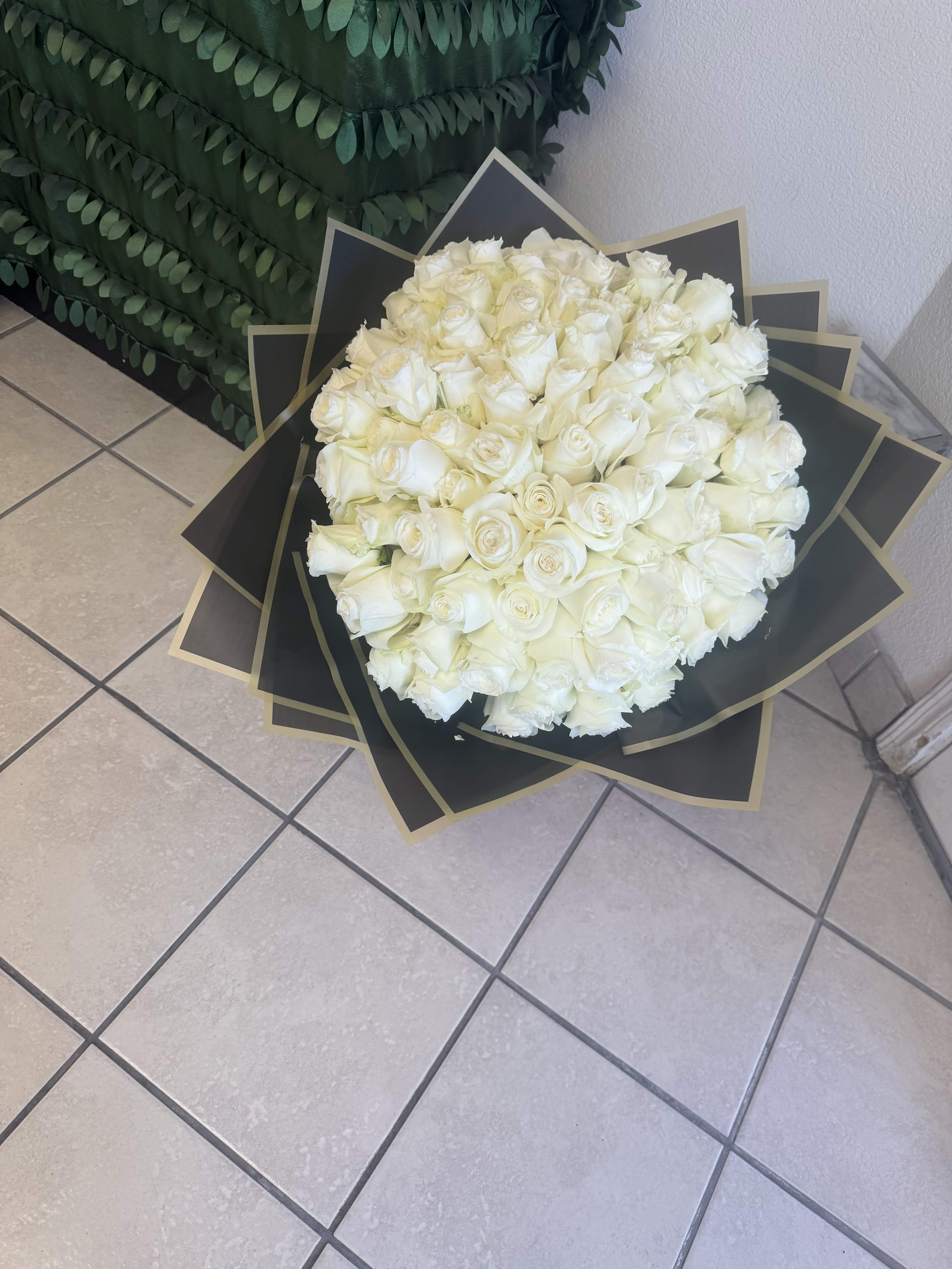 100 Hand wrapped Roses 100 Hand wrapped Roses - 100 white roses hand wrapped in paper wrapping guaranteed to surprise that special love one on any occasion. This arrangement can also be made with a variety of other color rose. Please contact us for color choices