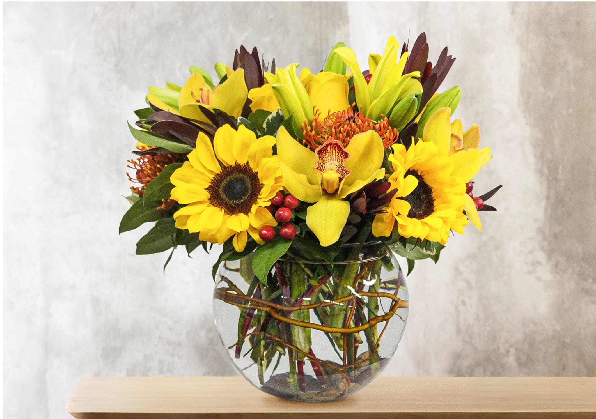 Splendor - This unique design includes sunflowers, yellow lilies, cymbidium orchids, pin cushion protea, yellow roses, St. John's wort berries, safari sunset. 