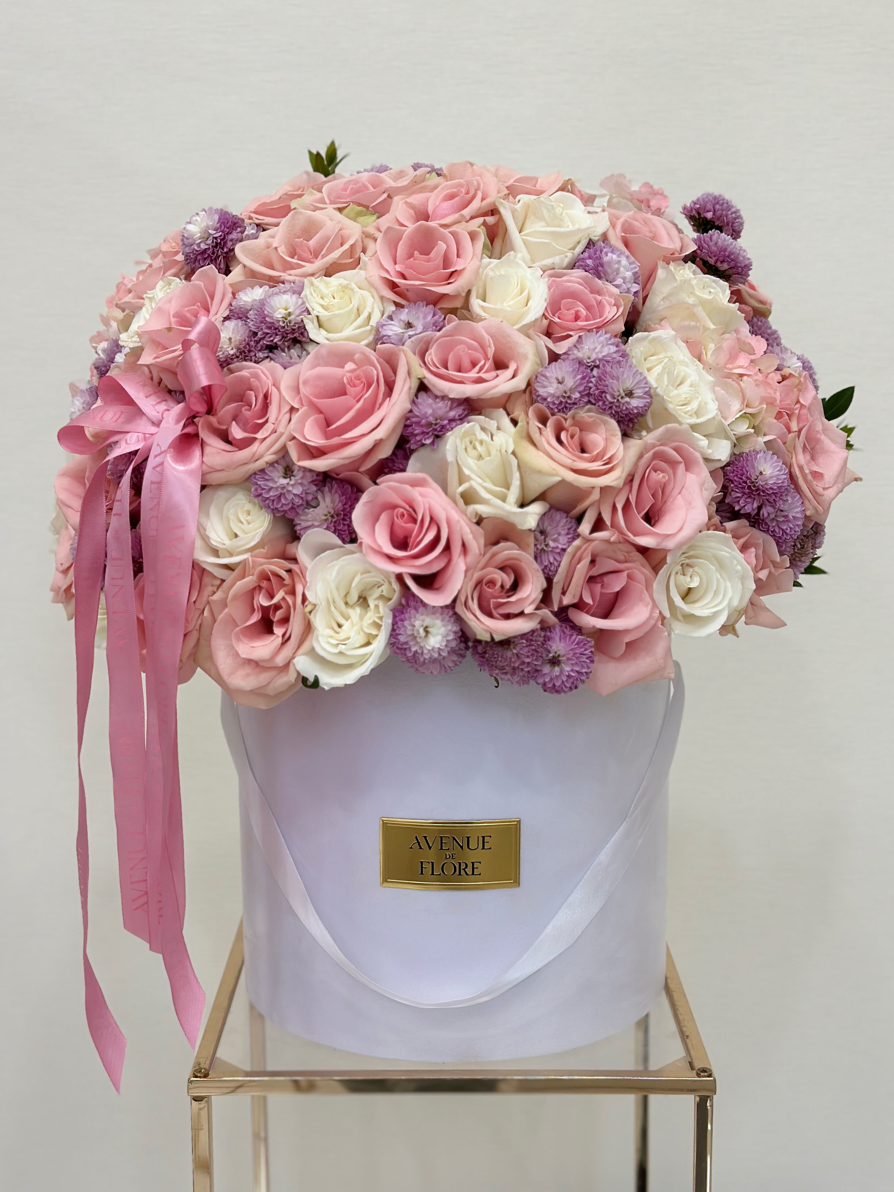 Hello Gorgeous - A captivating blend of delicate white, pink, and lavender blooms presented in a luxurious white velvet box. Whether you're celebrating a special moment or simply brightening someone’s day, our boxed flowers are designed to make a lasting impression.  