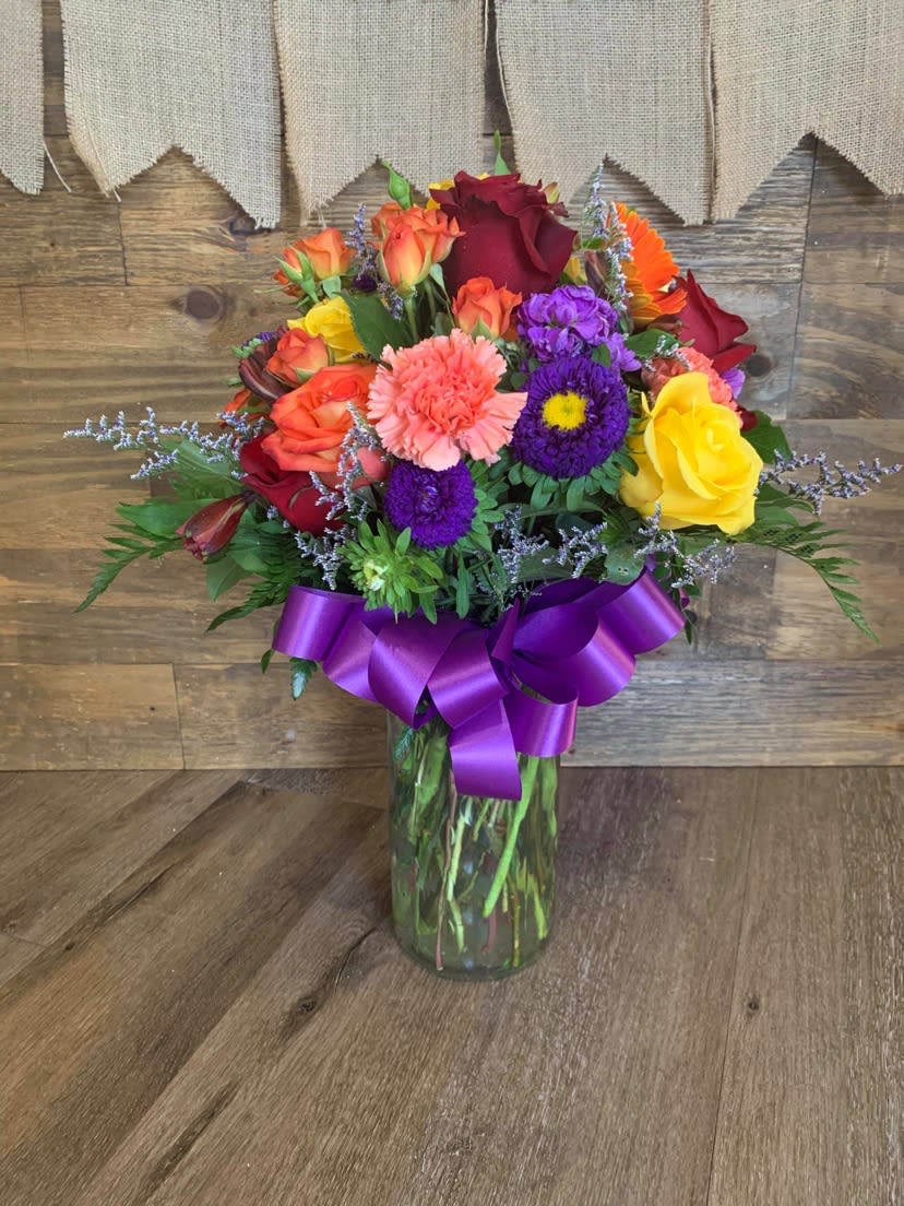 Country Sunrise - Delightful bouquet of purples, yellows, oranges, reds and more! This bright, elegant and cheery arrangement is sure to put a smile on anyone's face. 