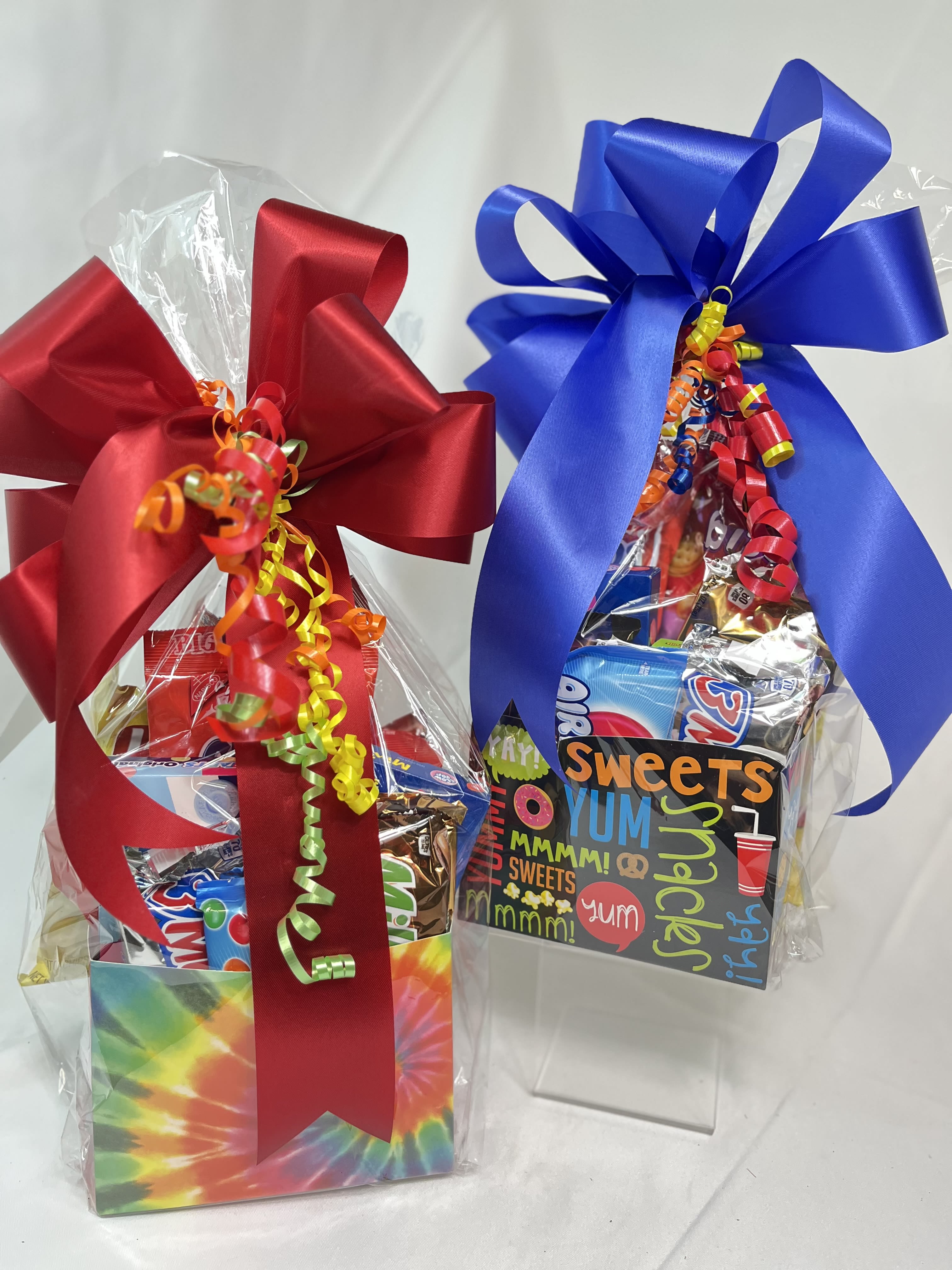 Snack Packs - Our best selling gifts for everyone, are our snack packs that are full of treats for all ages! The colorful themed boxes are full of sweet treats, chocolates, cookies, crackers, cookies and more!! Tied up in a cello bag with a big bow, this gift brings big smiles to all recipients!!! Request a holiday, birthday, sports, snacks, camouflage, unicorn, happy face, brights, pink  themes!! 