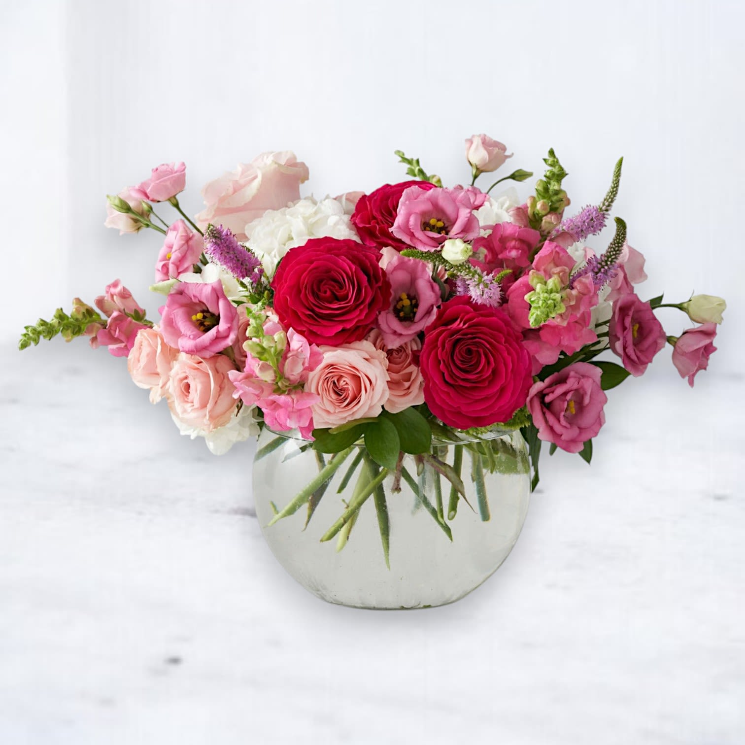 Rosé Rhapsody - A dreamy blend of romance and elegance, the Rosé Rhapsody bouquet is a captivating symphony of soft pinks, blush tones, and deep crimson hues. Featuring lush garden roses, delicate lisianthus, fresh hydrangeas, and snapdragons, this arrangement is artfully designed in a modern glass bowl for an airy, graceful touch.  Perfect for birthdays, anniversaries, or simply celebrating the beauty of everyday moments, the Rosé Rhapsody is an exquisite floral gift. Available for same-day delivery in Houston and surrounding areas, this bouquet is a timeless expression of love and appreciation.  