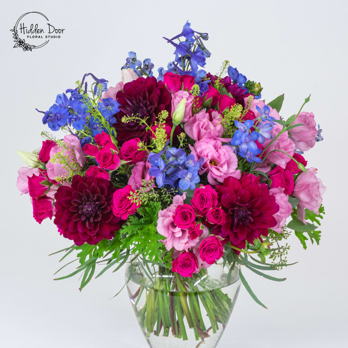 Soiree Soiree - Colorful boquet to celbrate art, music, good wine and friendship made with Spray roses, lisianthus, blue delphinium and dahliahs (or similar substitution when dahliah are not available). Please pre-order at least 24-48 hrs ahead.