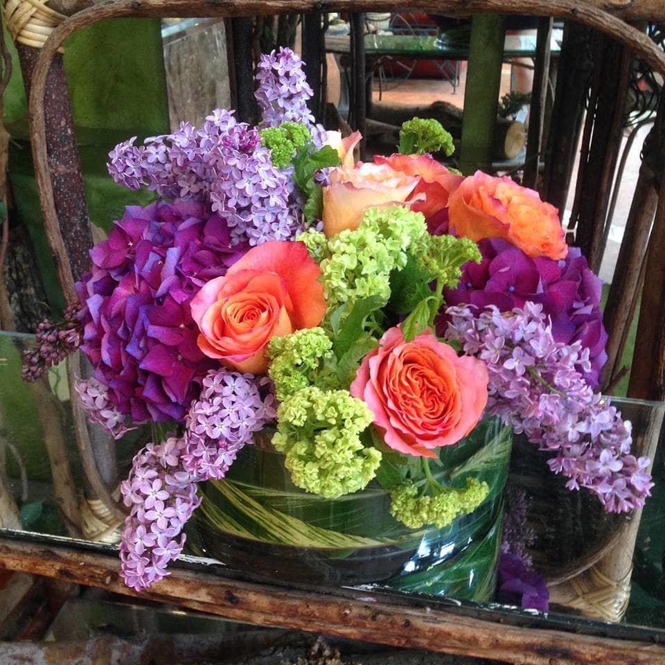 Midnight in Paris - Bright and fresh spring flowers (Dutch hydrangea, Lilac, roses) in a large round vase. Note: lilac only available in the spring.