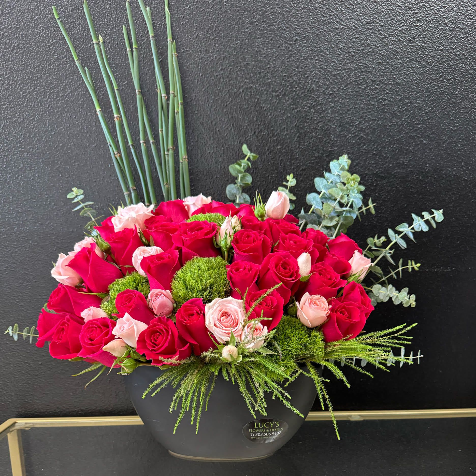 Vivid Blossom Vivid Blossom - “A true celebration of luxury, this jewel-toned arrangement commands attention. A stunning blend of light and dark pink roses, alongside other unique blooms, comes together in a floral masterpiece that will captivate anyone who sees it.” Arrangement Includes: -Fresh Cut Roses, Dianthus & Other Blooms -Black Ceramic Vase -Custom Greeting Card -Care Instructions