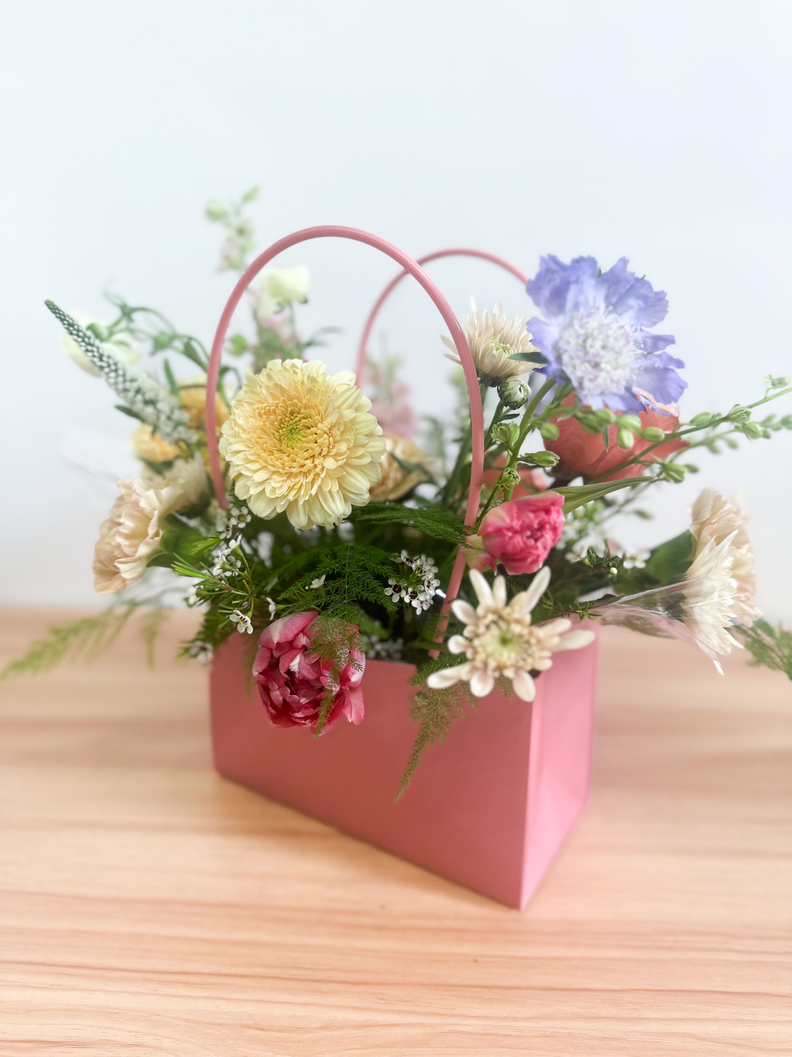 Just for Mom - This cheerful and whimsical box of blooms is the perfect gift to brighten anyone’s day! The flowers are artfully arranged in a container, nestled inside a gorgeous presentation box for a beautiful, ready-to-give experience. The combination of vibrant colors and playful design makes this arrangement a delightful surprise for any occasion. Whether it's a celebration or just a thoughtful gesture, this convenient, all-in-one floral gift is sure to bring joy and smiles.