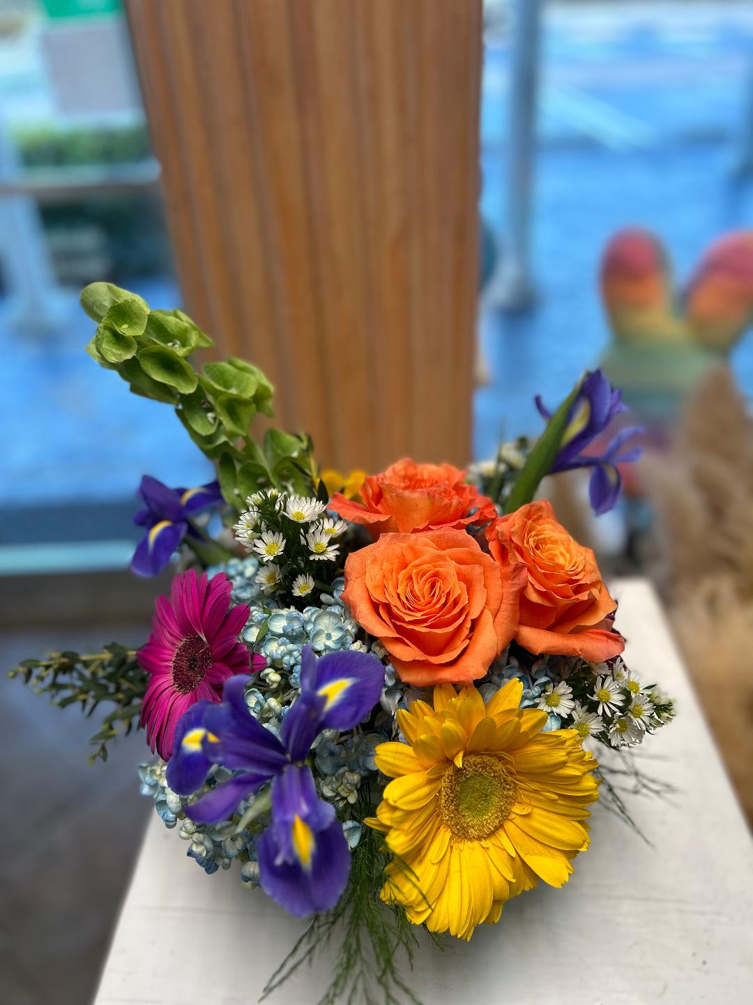 CFE170 CFE170 - A low compact arrangement of hydrangeas, roses, gerbers and other flowers in bright vibrant tones.