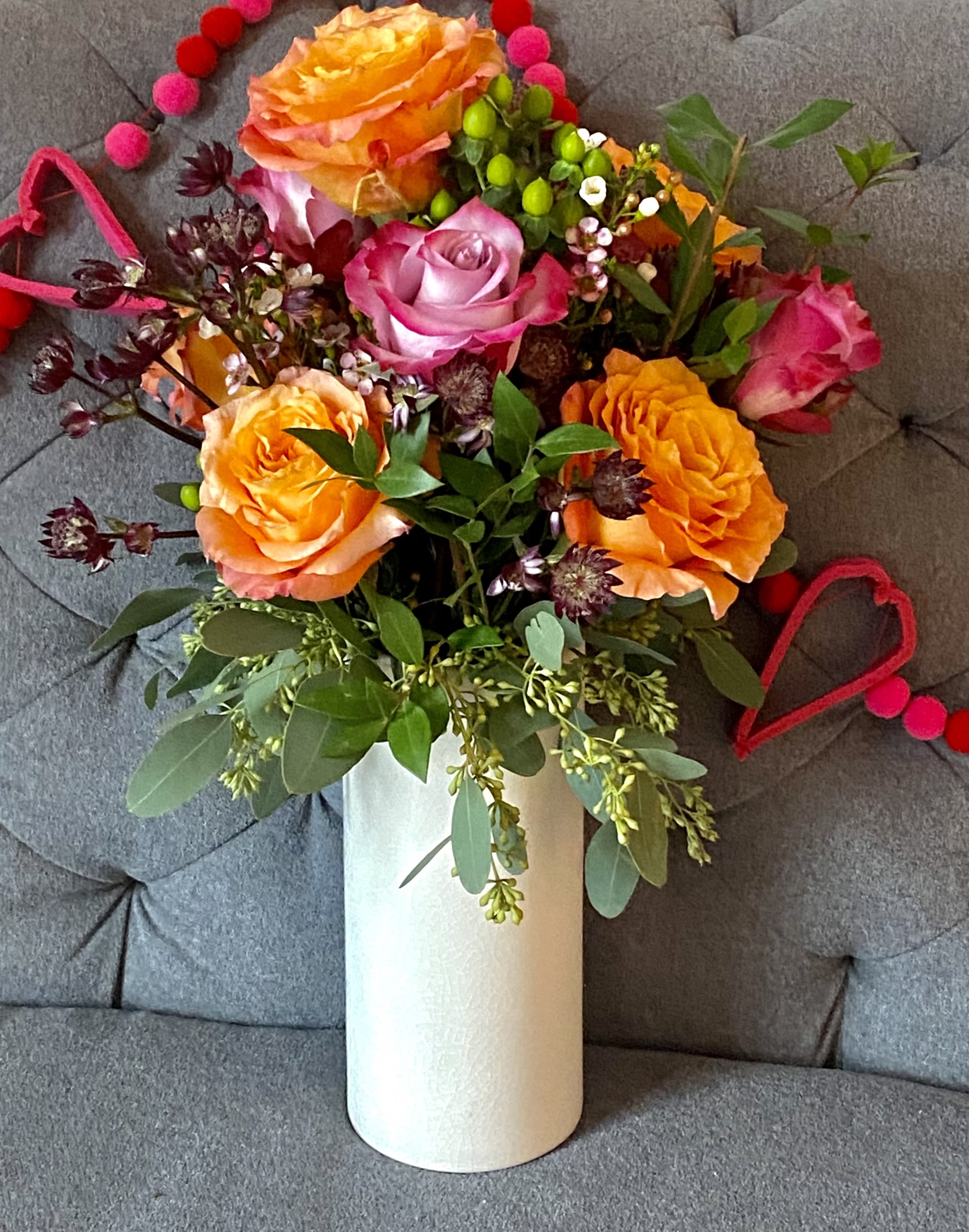 The Peach Fuzz! - Its so pretty sorry that's our first reaction!  Peach roses which are gorgeous with some raspberry cream roses and some mini flowers designed in a white ceramic or glass vase.  Its such a pretty look or Valentines and any day!  Fan favorite!!!  Standard comes in a thinner clear vase and is approx 6 peach roses and 6 raspberry   Deluxe comes in a white glass rose vase and is approx one dozen peach roses and 10 raspberry  Premium white ceramic tall vase with 1 dozen peach and 1 dozen raspberry 