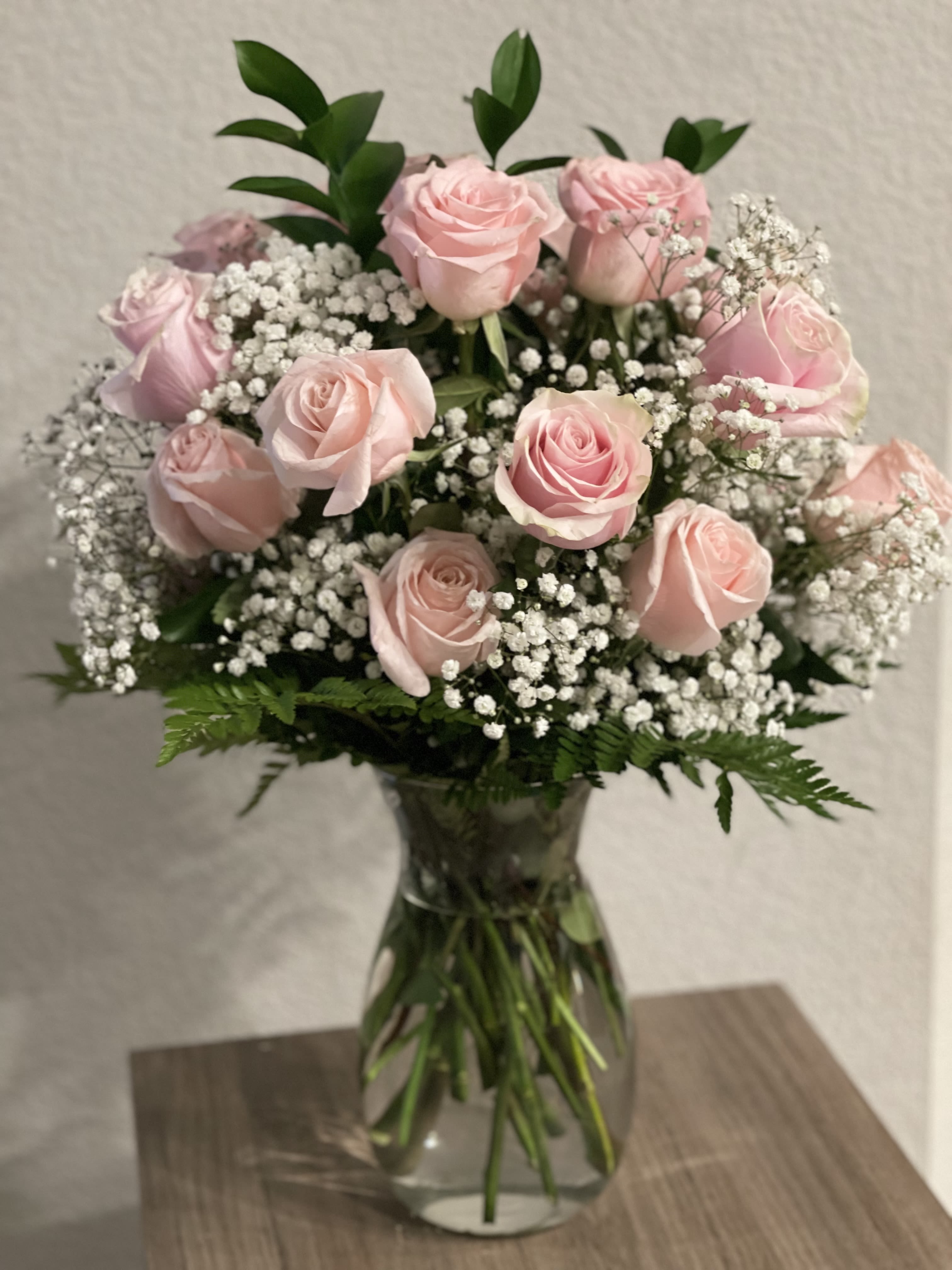 You’re a Star  - Stunning floral arrangement of 24 light pink roses, baby’s breath and assorted greenery on a tall clear vase with an elegant bow. 