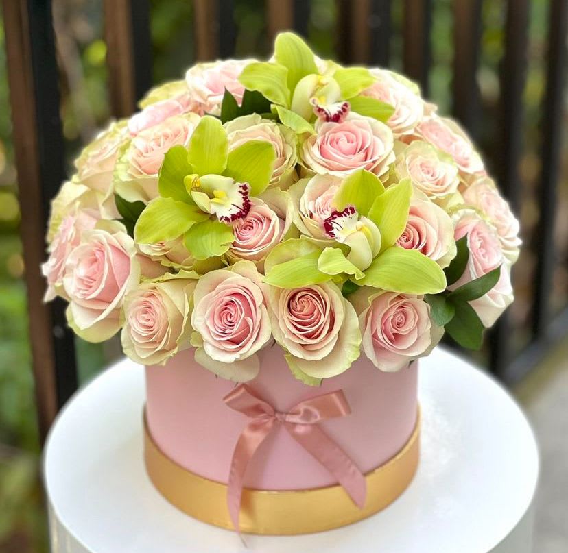 Rosa Floreciente  - Pink roses and green orchids: These blossoms are the stars of the arrangement. The pink roses symbolize love, gratitude, and admiration, while the green orchids add an exotic touch.