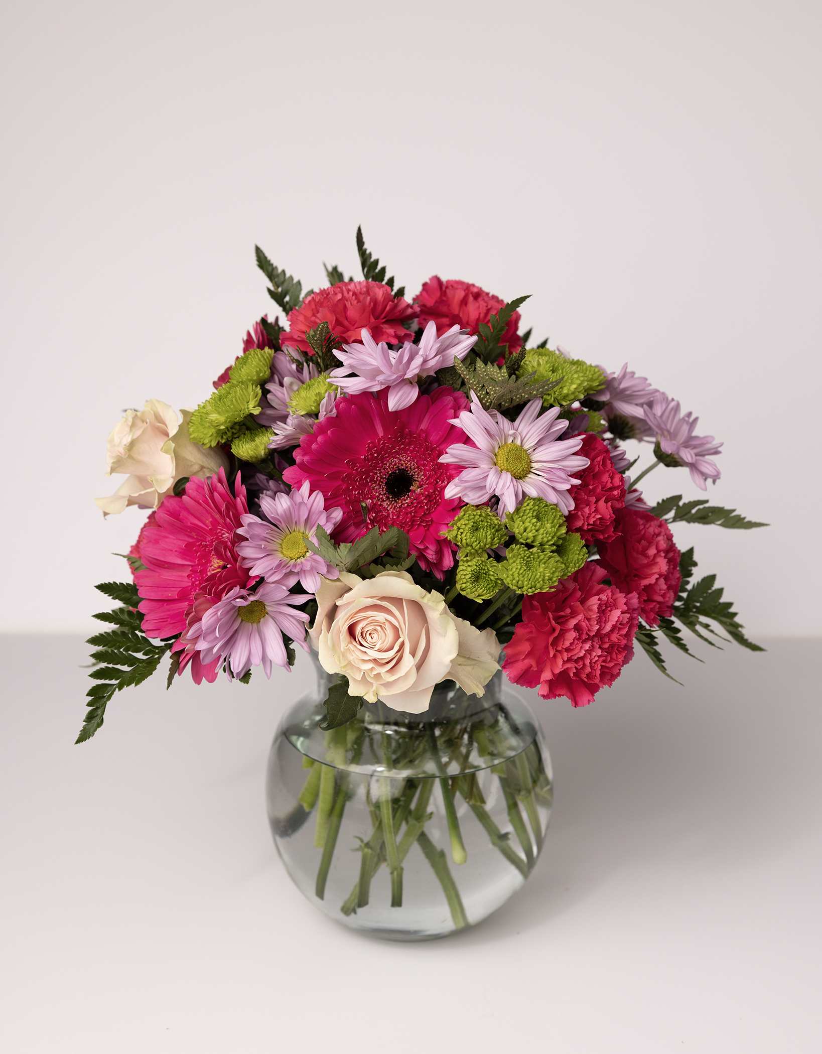Modern Blooms - Brighten your space with this stunning vase arrangement featuring a delightful mix of roses, daisies, button flowers, and carnations. (Colors may vary for a unique touch!)