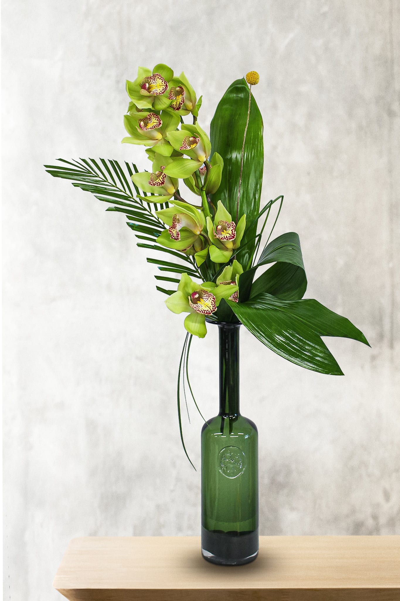 Cymbidium Delight  - This elegant design includes a full cymbidium orchid stem, with tropical foliage. 