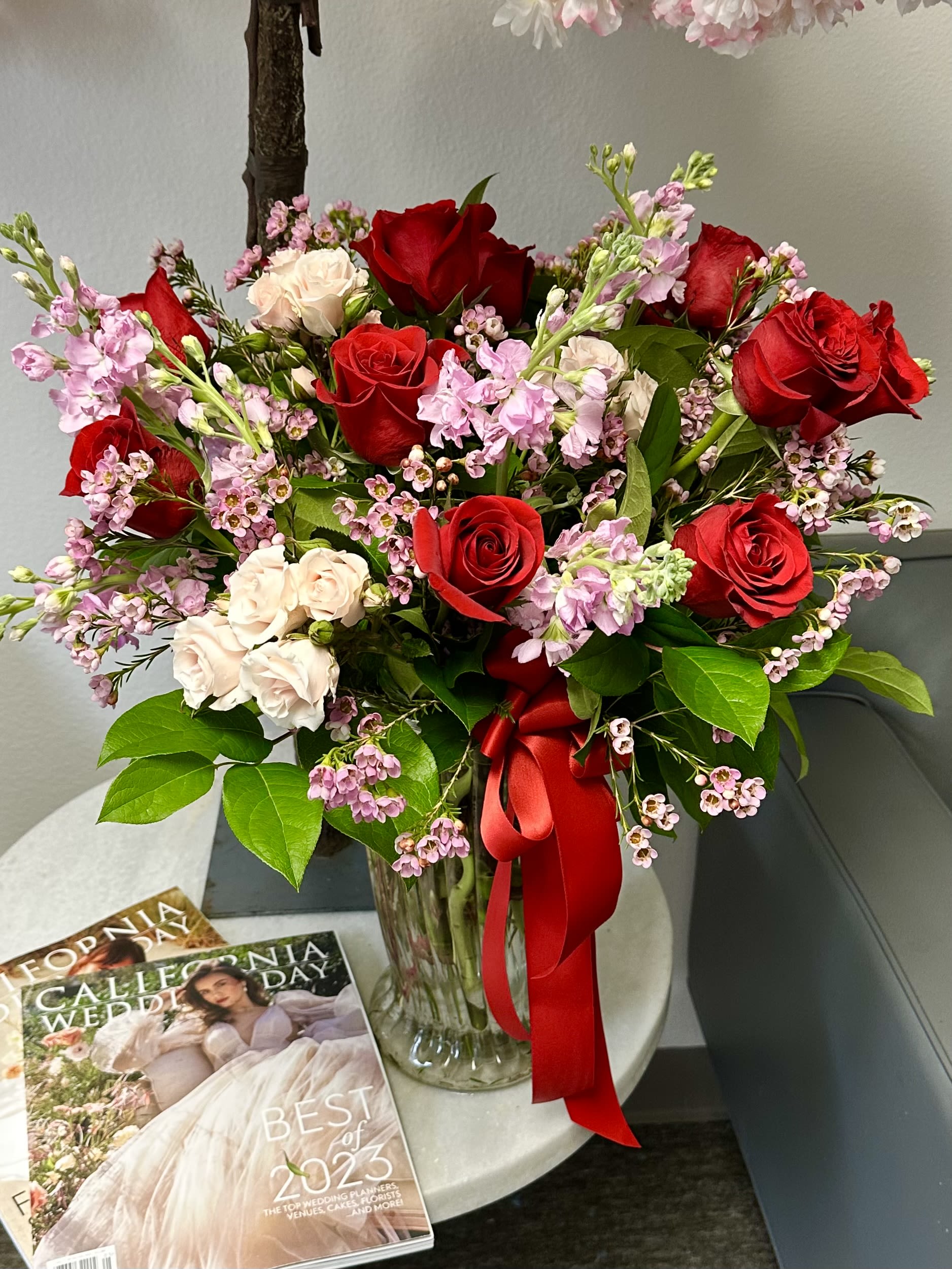 Mix tall vase arrangement with pink and red flowers - Red roses with blush spray roses, stock and other flowers in a vase