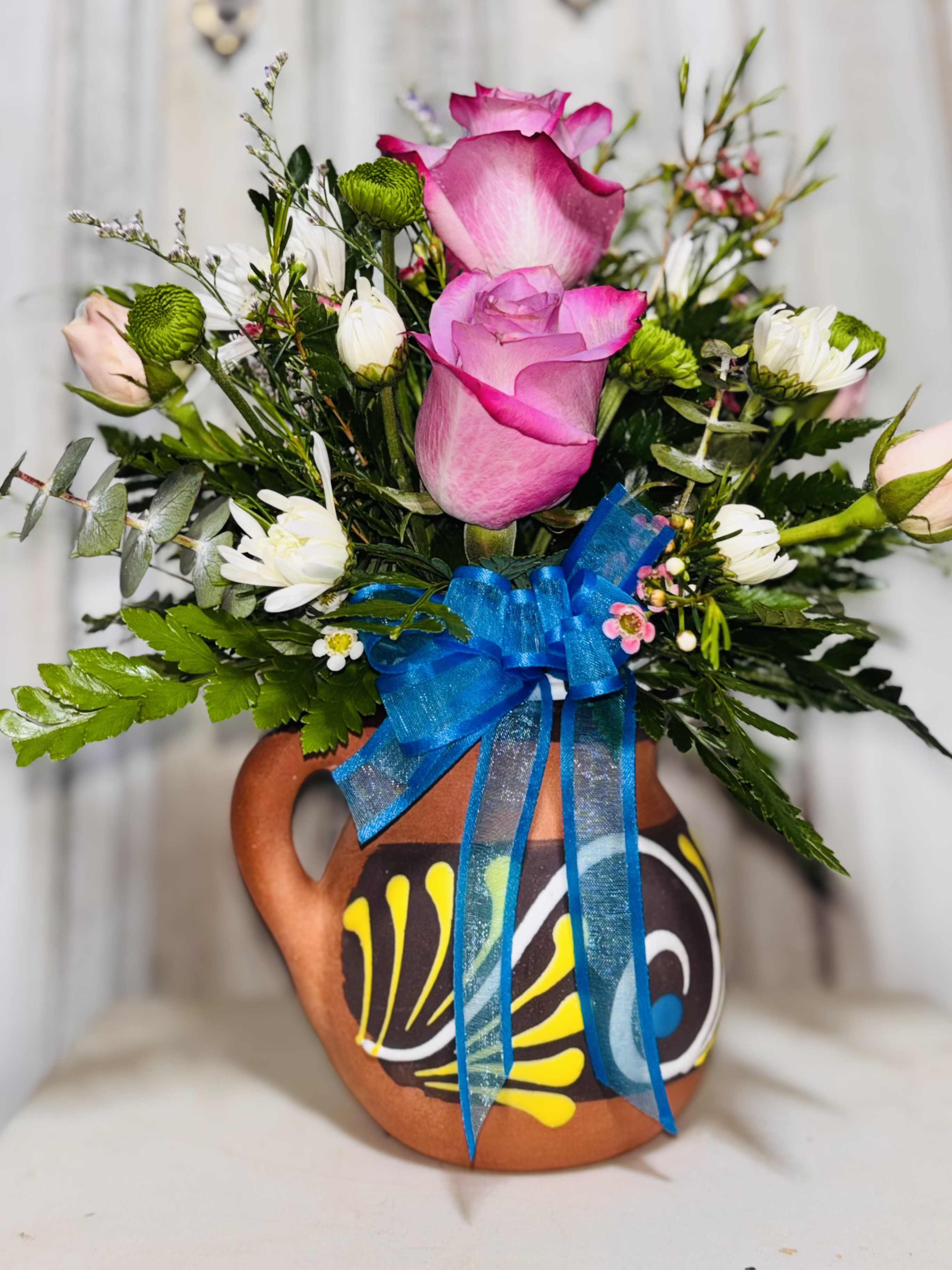 Cup of flowers Cup of flowers - This arrangement contains a pottery cup with roses, spray roses, poms and greenery filler.