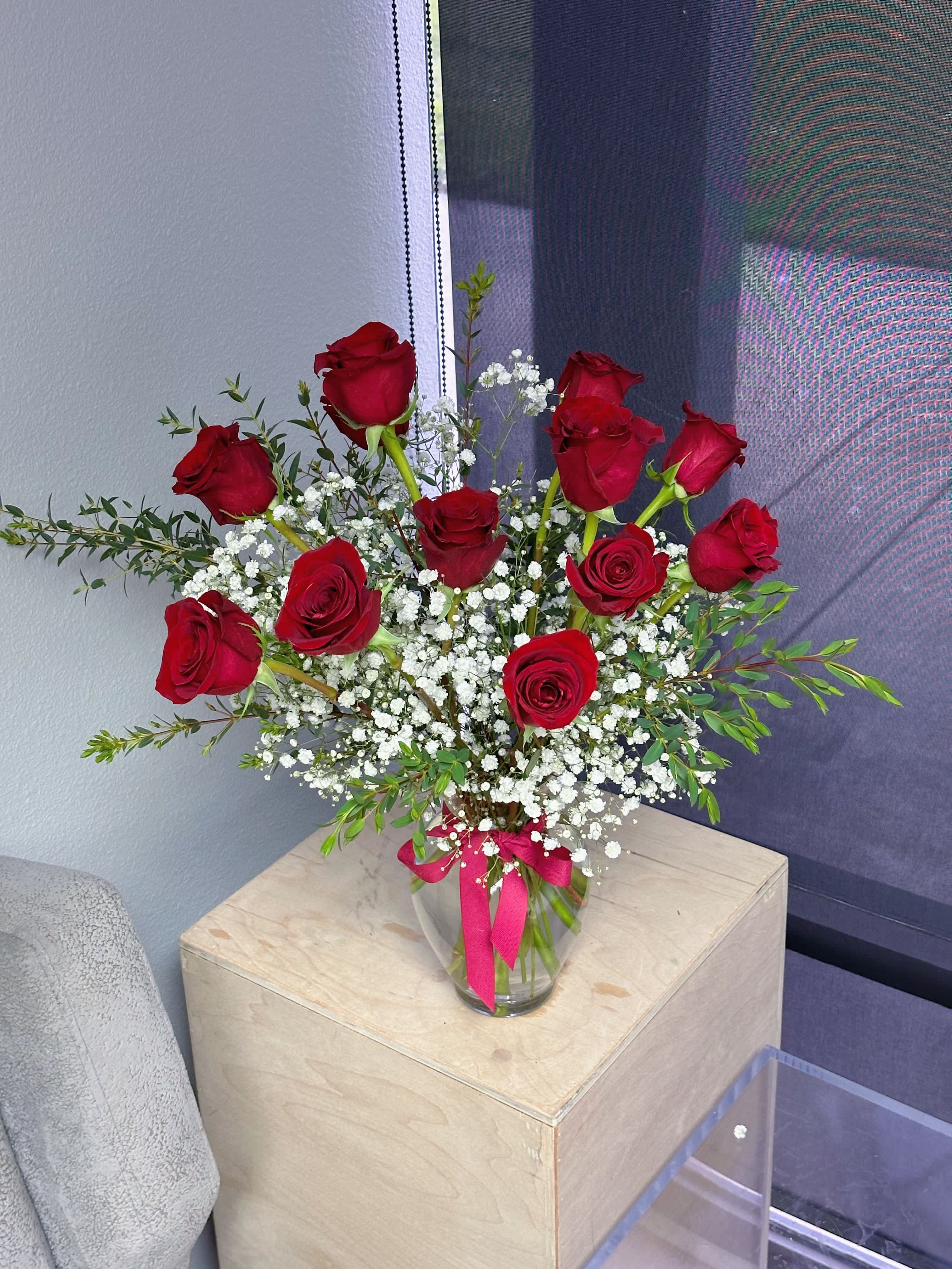 One dozen red roses in a vase - One dozen red roses with greenery and gypsophila in a vase 