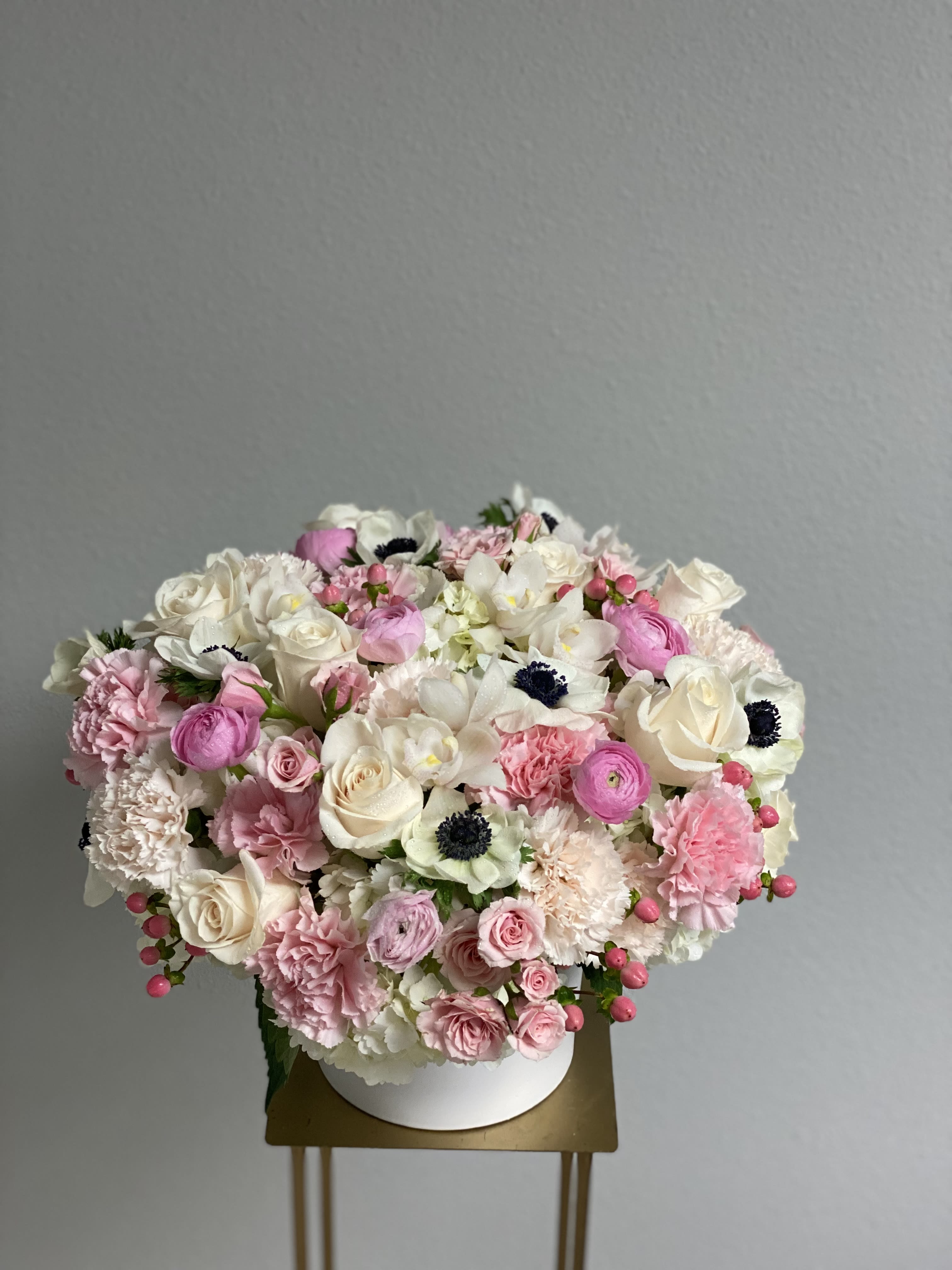 Arrangement with anemones and orchids  - Arrangement with lots of different flowers: anemones, orchids, roses, spray roses, ranunculus, berries, carnations.