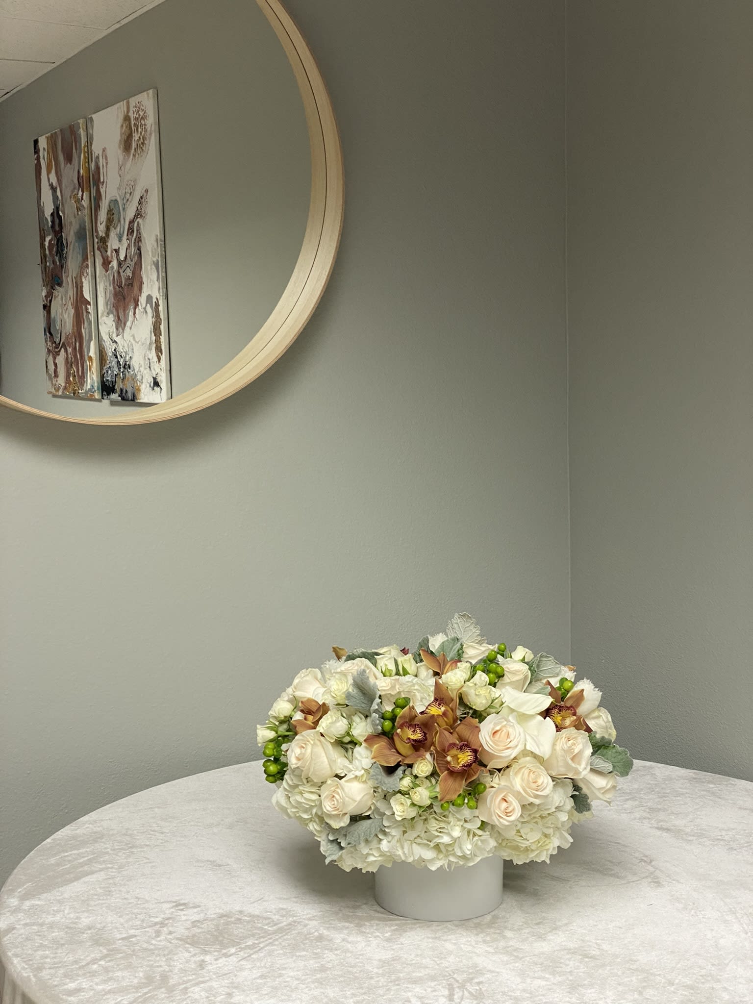 Arrangement with cymbidium orchids  - Arrangement in a vase with cymbidium orchids, roses, spray roses, hydrangeas, tulips, greenery and berries.