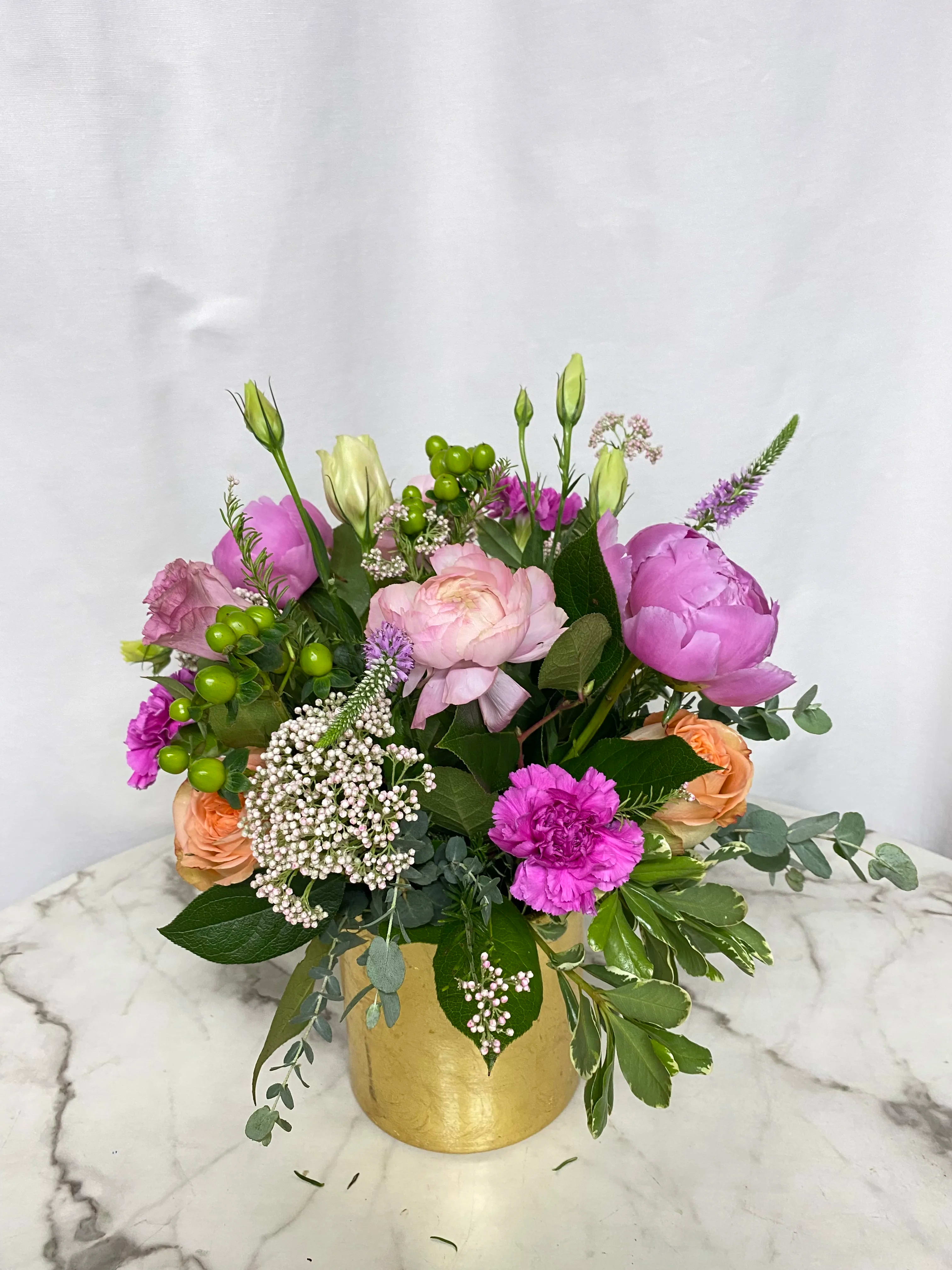 Celebrate ( design of the day) in a gold vase  - The designer will select only the best flowers of the day to create arrangement or bouquet inspired by the seasonal beauty of the flowers.  PLEASE NOTE: The flower selection in the picture is for the design sample and to represent the sizes. The selection of the the flower and color schemes will vary due to seasonal availability.