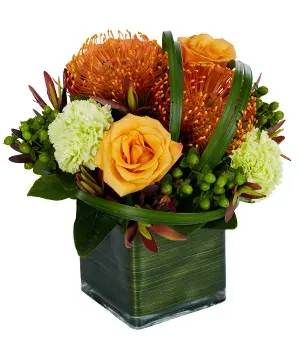 Tropical Sophistication Bouquet - The Tropical Sophistication bouquet is made with pincushions orange roses, green hypericum, green carnations, safari sunset flowers, on a crystal square vase covered with green TI leaf.