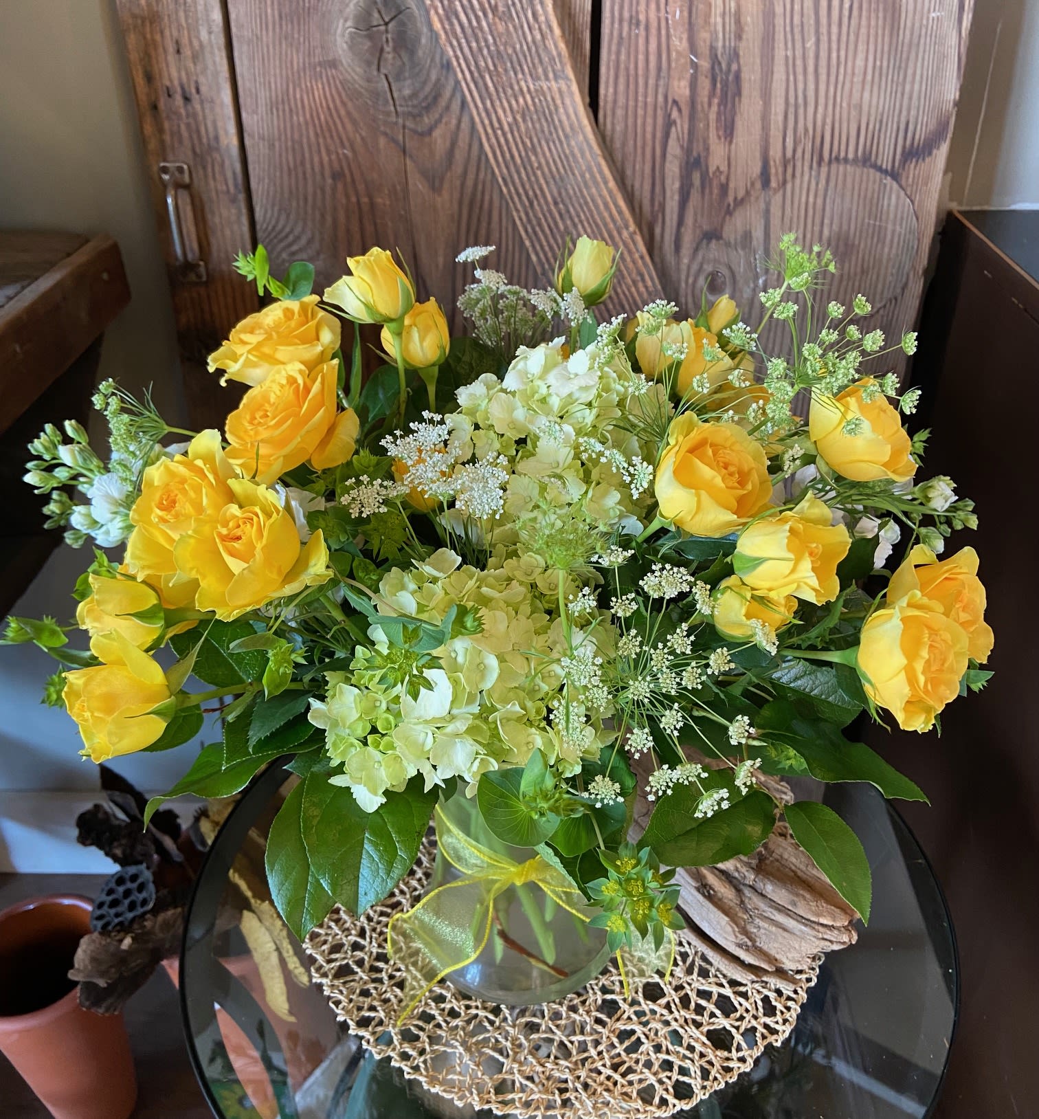 Sweet Sunshine Sweet Sunshine - Fluffy yellow spray roses, hydrangeas, stock and queen anne's lace displayed in a clear vase and yellow ribbon.