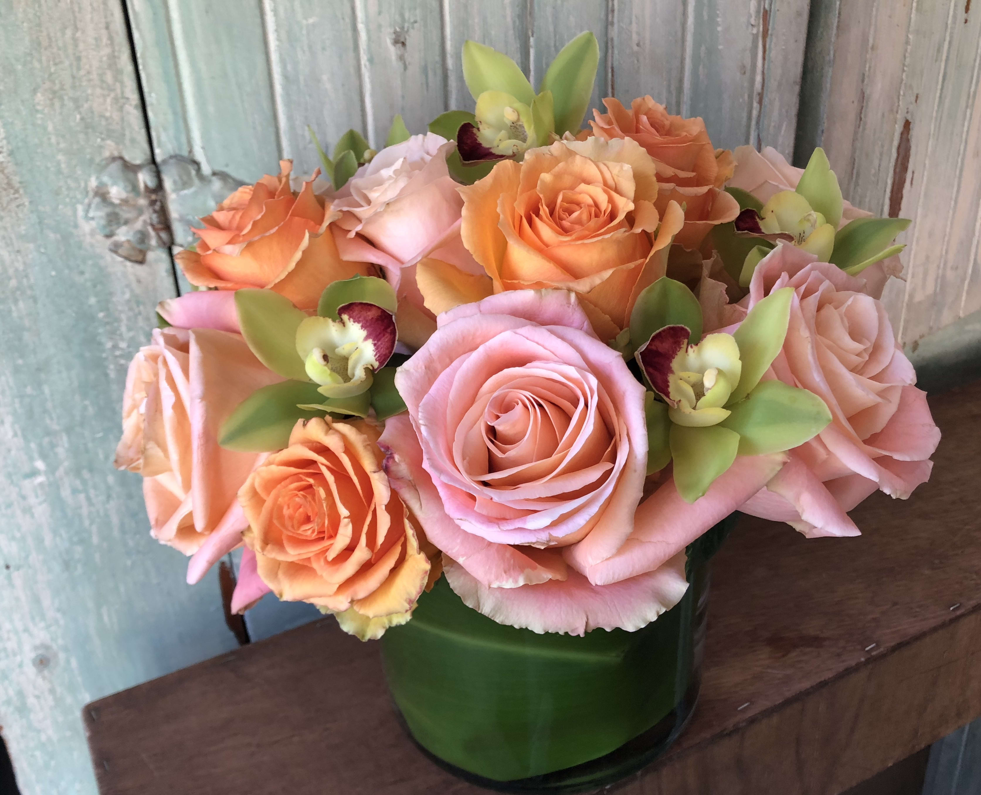 Bright Rose Bowl Bright Rose Bowl - Mix of orange & pink roses set in to 6" glass bowl with green mini cymbidium orchid detail. This arrangement can be made is assorted colors. Due to covid related shortages we may not be able to match the arrangement exactly. Containers or flowers may substituted at designers discretion. Thank you for your understanding.