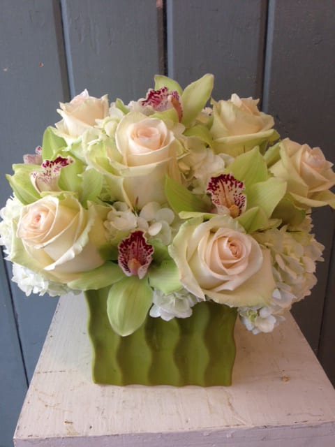 Creme de la Creme Creme de la Creme - creme de la creme roses with white hydrangea & green cymbidiums -This container is out of stock Will be set into a similar substitute. This arrangement can be made in an assortment of colors.