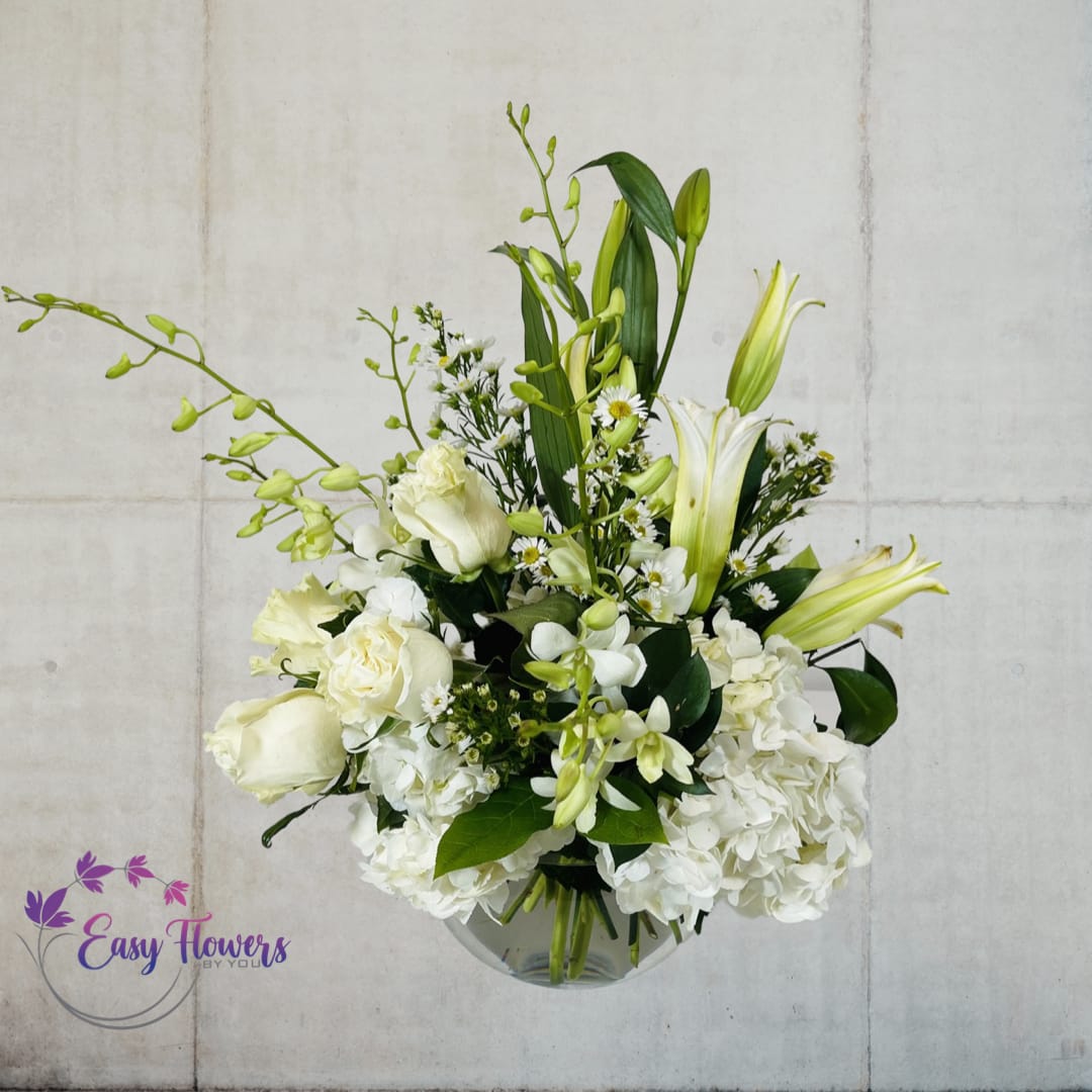 White Elegance - Discover the Beauty of Our Elegant White Flower Arrangement - Looking for a stunning selection of beautiful white flowers that are arranged with artful simplicity? Our elegant bouquet features a stunning assortment of white flowers, expertly arranged in a clear glass vase for a timeless and sophisticated look. Perfect for any occasion, this beautiful arrangement is sure to make a lasting impression. Order now and experience the beauty and elegance of our exquisite white flower arrangement.