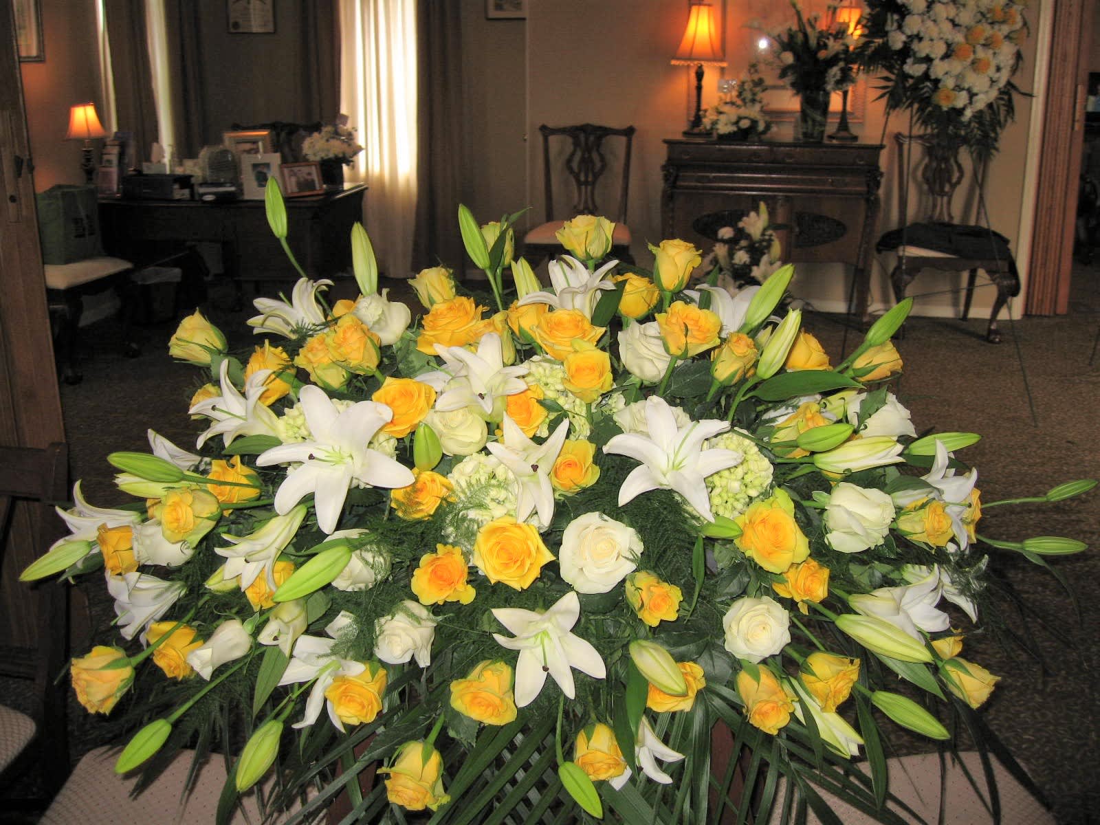 ETERNALLY YOURS CASKET COVER   (Click on Picture for Best View) - Casket Spray is a wonderful way to commemorate a life abundant in beauty and love.  White Lilies,White and Yellow Roses, Fancy Assorted Greens Spray Designed &amp; Photographed by us.