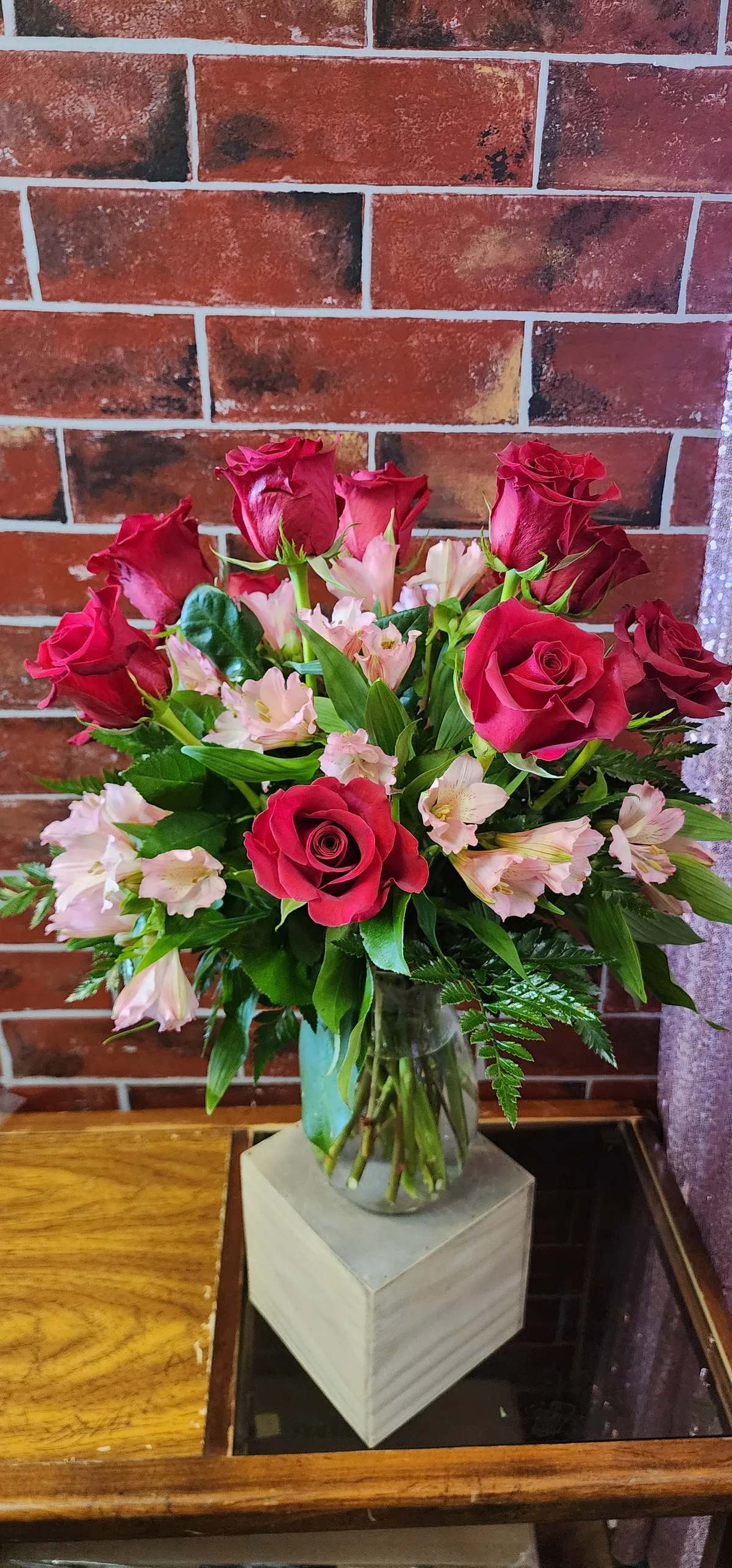 Roses and Pink Alstromeria - A beautiful all around arrangement designed with fresh flowers to include 12 red roses and pink alstromeria with greens.  * Some stages of flower life may vary. (Example: Lilies may be more open than imaged.)  Flower shortages and product availability means that some substitutions will apply. Value will always be filled. This bouquet might include eucalyptus amongst the greenery. It may be toxic to pets including but not limited to Cats and Dogs if digested.