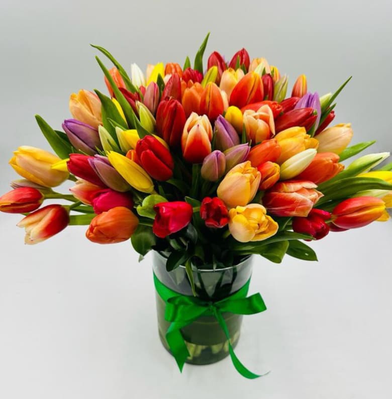 Assorted Tulips Assorted Tulips - This beautiful bouquet of assorted tulips will make their day! Standard comes with 24 tulips. Deluxe comes with 50 tulips. (Colors are assorted and arranged in a clear vase)