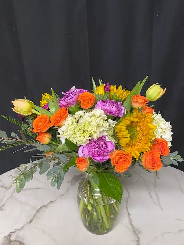 Bright Day ( design of the day) Vase arrangement   - The designer will select only the best flowers of the day to create arrangement or bouquet inspired by the seasonal beauty of the flowers.  PLEASE NOTE: The flower selection in the picture is for the design sample and to represent the sizes. The selection of the the flower and color schemes will vary due to seasonal availability.