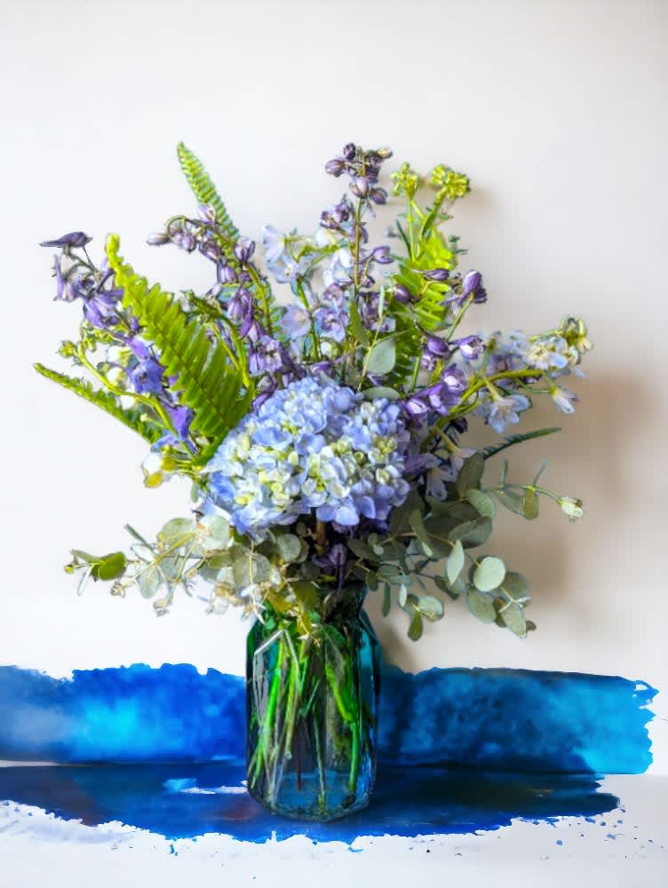 &quot;Serenity&quot; from the Rainbow Collection by Art &amp; Flowers - Introducing &quot;Serenity&quot; from the Rainbow Collection by Art &amp; Flowers—a tranquil all-blue floral arrangement that embodies peace, calm, and elegance. This soothing creation features a harmonious blend of hydrangeas and delphinium pleasantly arranged to evoke a sense of serenity and grace. Perfect for any setting, &quot;Serenity&quot; brings a touch of refined beauty and relaxation, making it the ideal choice for expressing sympathy, appreciation, or to simply create a peaceful atmosphere. Let the cool hues and serene design of &quot;Serenity&quot; bring a calming presence to your space.