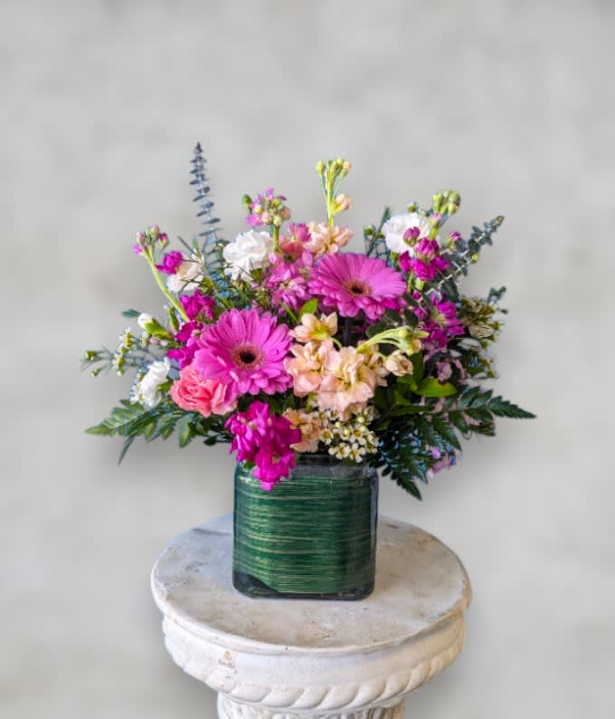 Art & Flowers Exclusive "Loves Garden" Art & Flowers Exclusive "Loves Garden" - Introducing Love's Garden: A Victorian-inspired cube arrangement that brings the charm of a blossoming garden into your home. Bursting with vibrant hues of pinks and purples, this exquisite arrangement features a delightful blend of stock, carnations, gerbera daisies, and more. Each bloom is meticulously selected to evoke the romance and elegance of a bygone era. Whether as a centerpiece or a thoughtful gift, Love's Garden exudes timeless beauty and enchantment, capturing the essence of a lush Victorian garden in every petal.