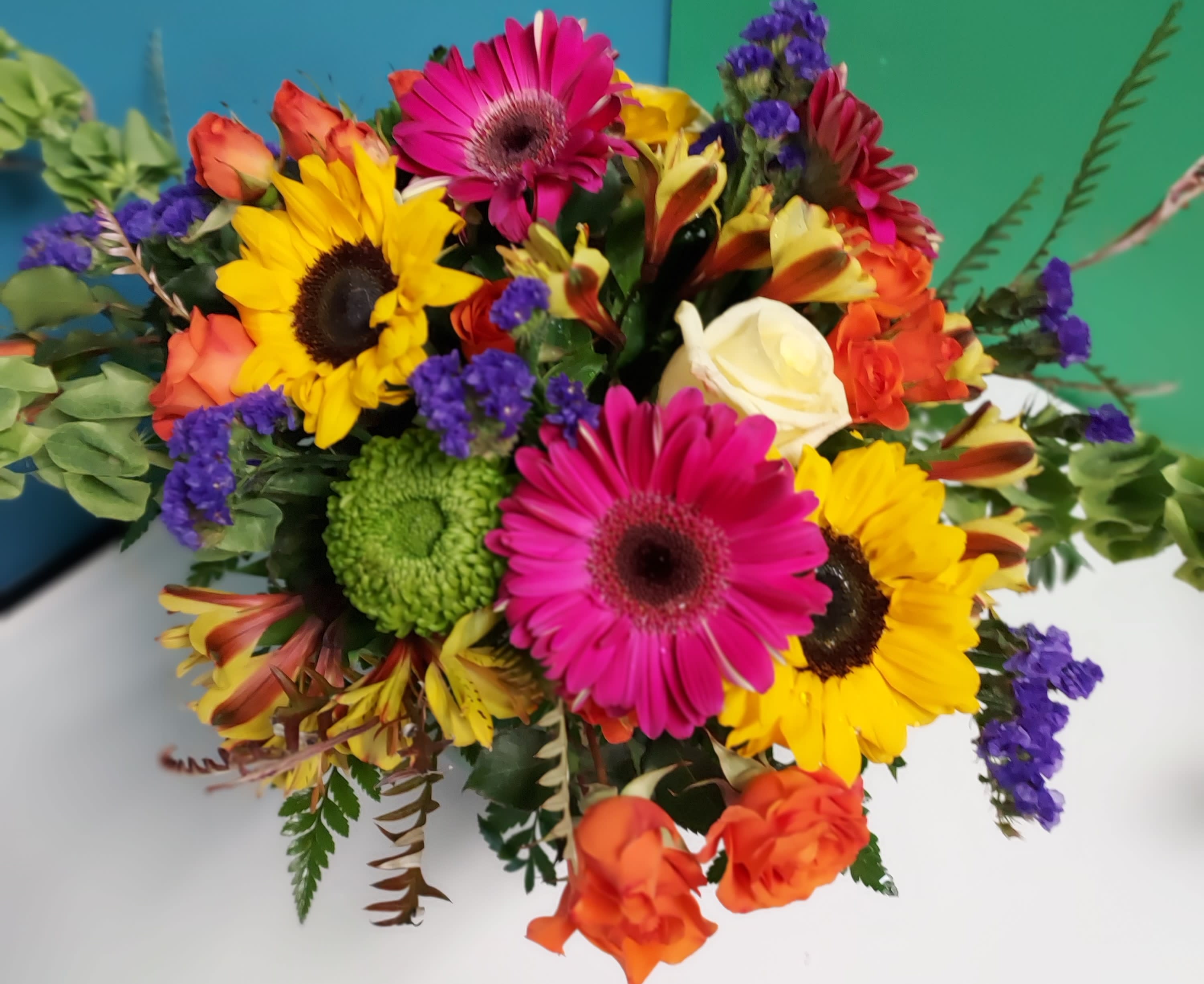 Sassy Sue By Art & Flowers Sassy Sue By Art & Flowers - Like the name implies this design is filled with the brightest and sassiest blooms we can find. Contents will vary due to availability.