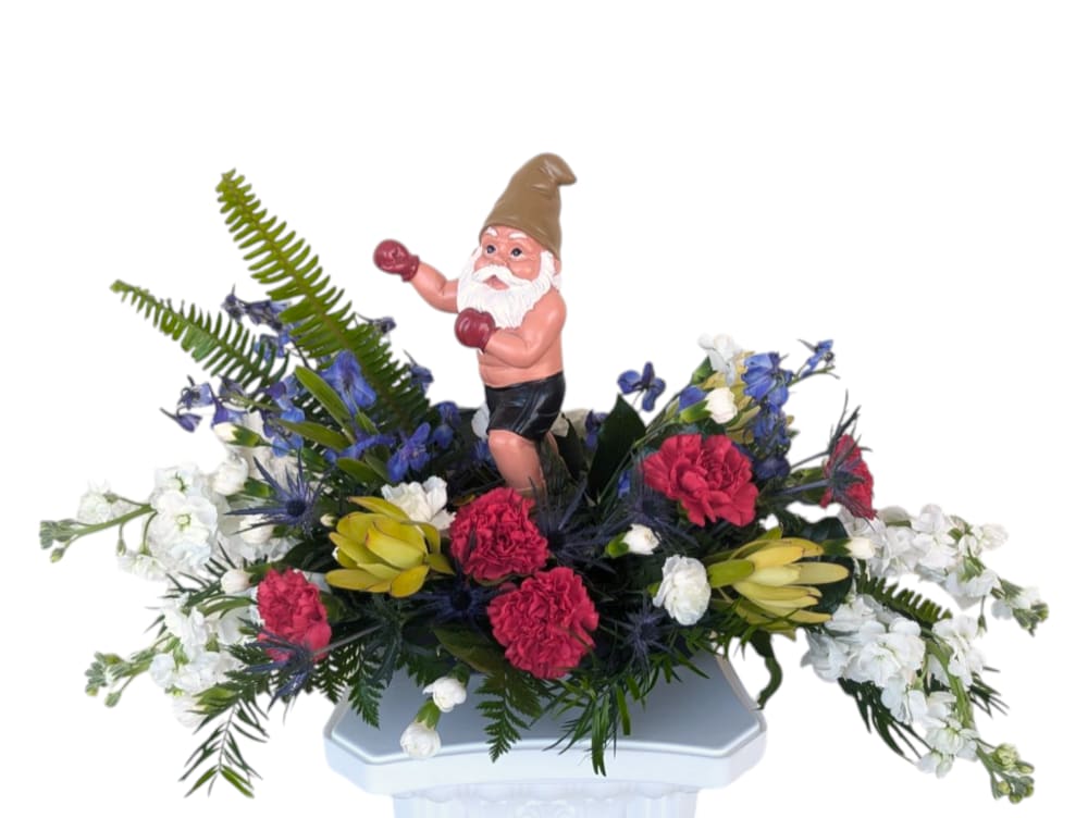 Knockout by Art &amp; Flowers - Knockout by Art &amp; Flowers packs a playful punch with a bold mix of vibrant reds, crisp whites, and striking blues, all surrounding a 10-inch tall boxing gnome. This unique arrangement delivers a fun and unexpected twist, making it a knockout gift for any occasion.
