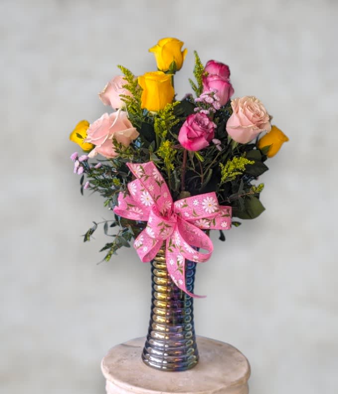 Pastel Dozen by Art &amp; Flowers - Presenting &quot;Pastel Dozen&quot;: A classic arrangement of a dozen assorted pastel-colored roses, elegantly displayed in a tall glass vase and finished with a timeless bow. This bouquet embodies the essence of timeless beauty with its soft, delicate hues, making it a classic choice for any occasion.  This arrangement can include roses in white, peach, pink, purple and yellow. 