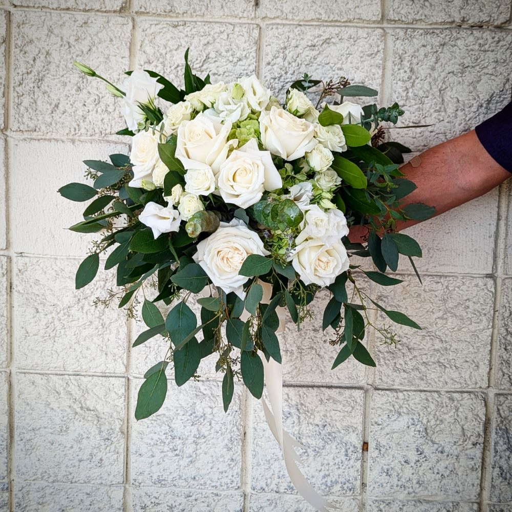 White Bridal Bouquet By Art & Flowers White Bridal Bouquet By Art & Flowers - A classic white bouquet hand tied with ribbon. The perfect accessory for any formal event including proms, weddings, and debutante balls.