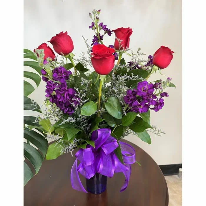 Red Hot Mama Red Hot Mama - This one turns up the heat! A full half dozen bright red roses, set off by deep royal purple stock, and bow.