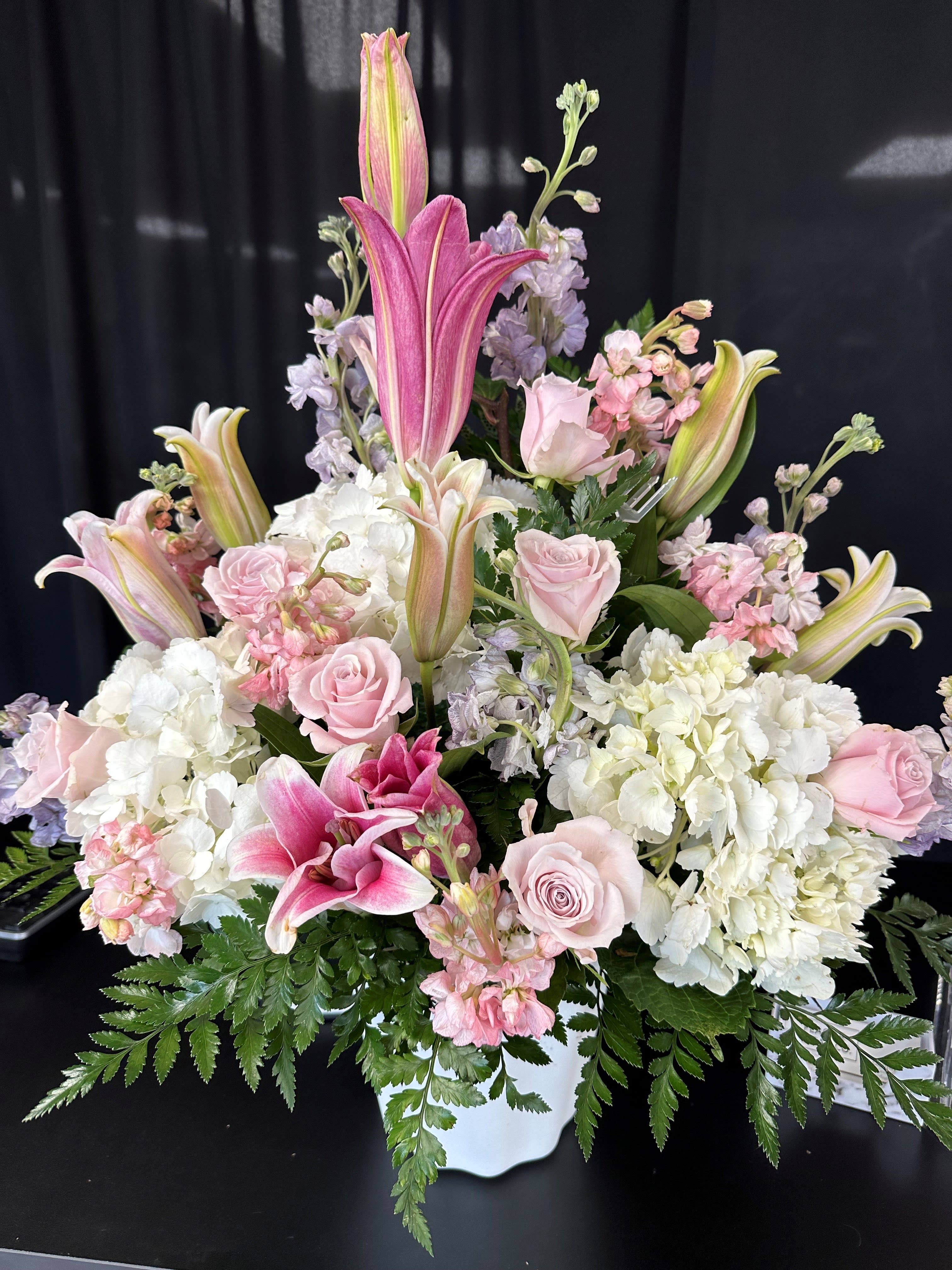 Pink Beauty - Pink lilies are adorned with white hydrangea, pink roses and pink and purple stock 