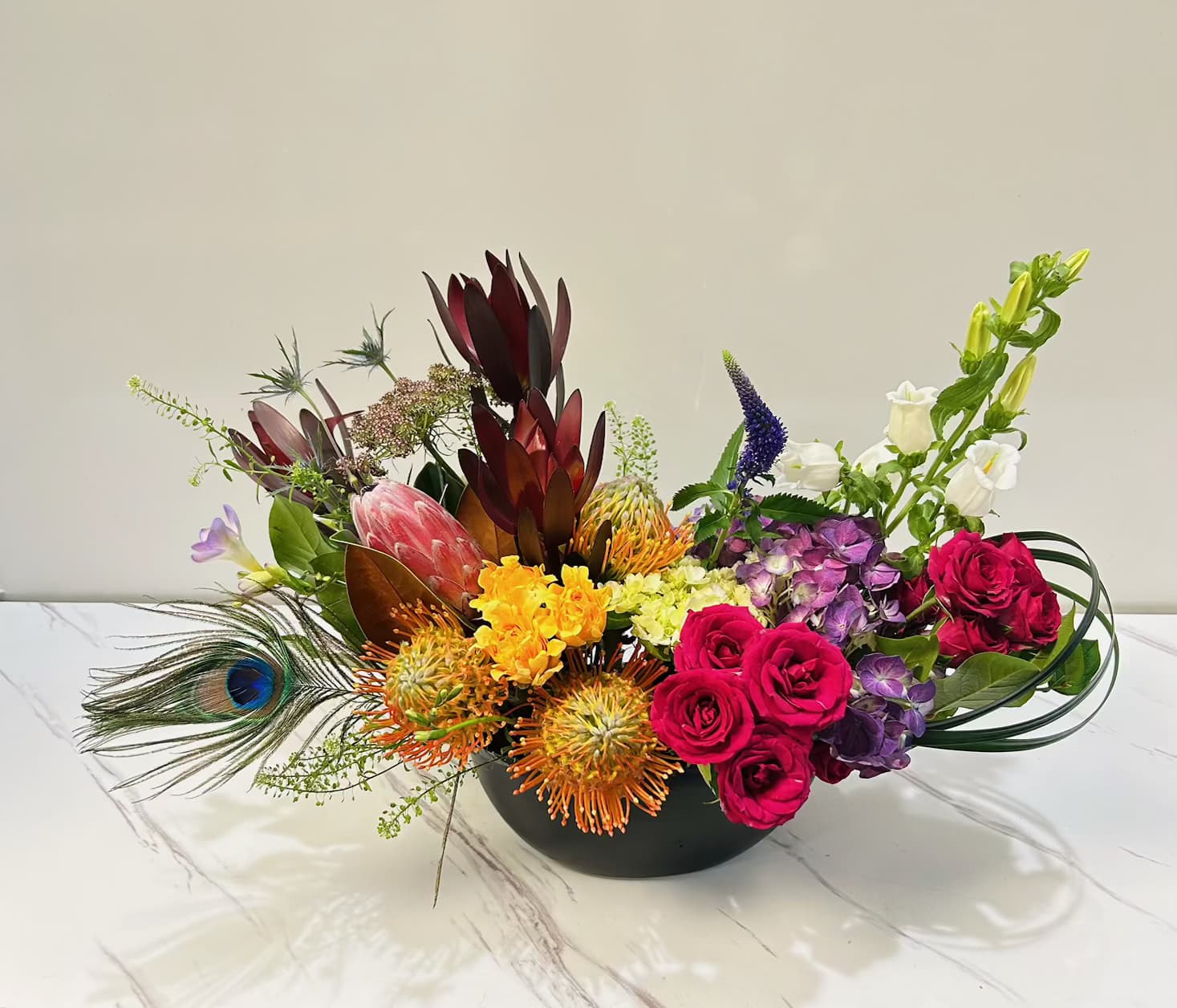Garden of Happiness  Garden of Happiness  - A burst of color and joy, this vibrant arrangement combines a lively mix of bright blooms, creating an uplifting and cheerful display. With every petal, it brings energy, warmth, and happiness—perfect for spreading positivity and brightening any space.